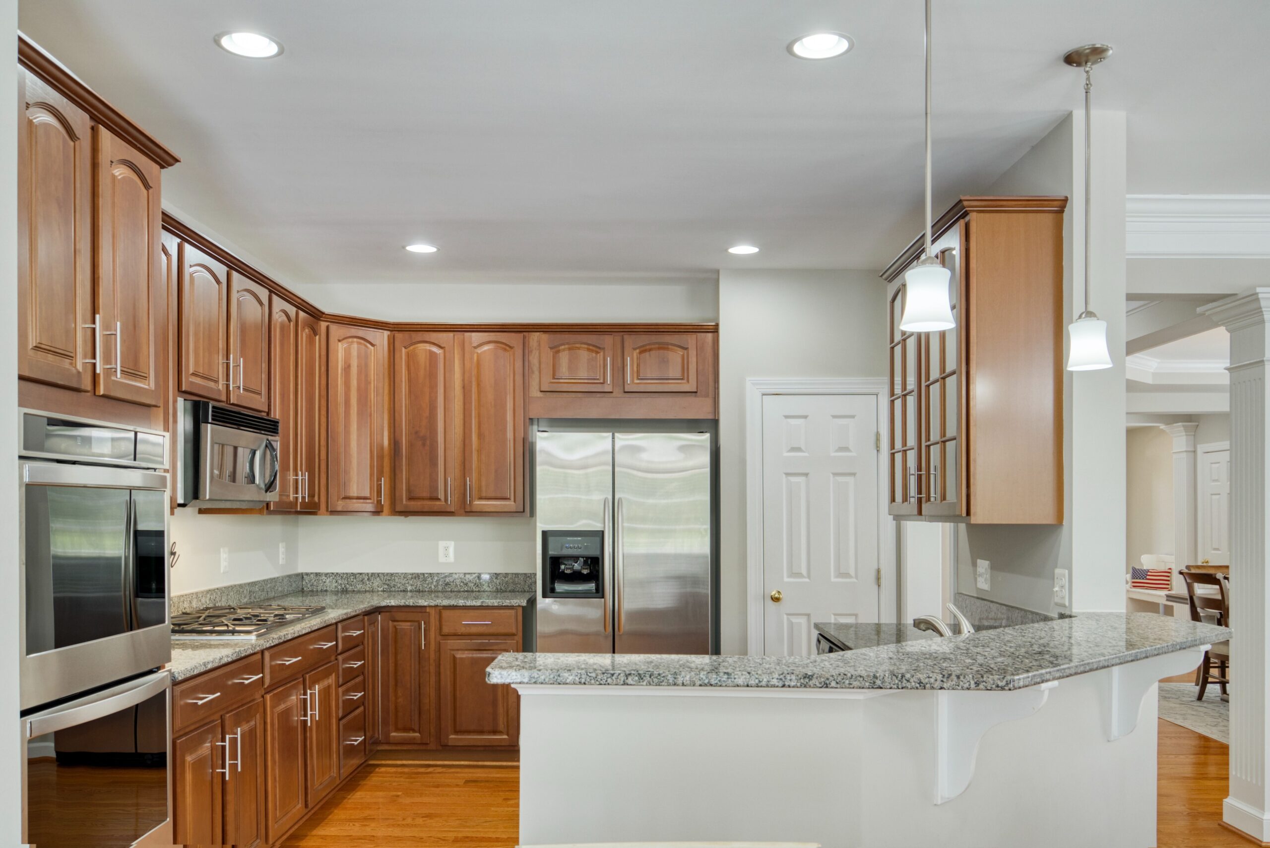 Townhome kitchen with walnut cabinets, stainless steel appliances and large granite counters