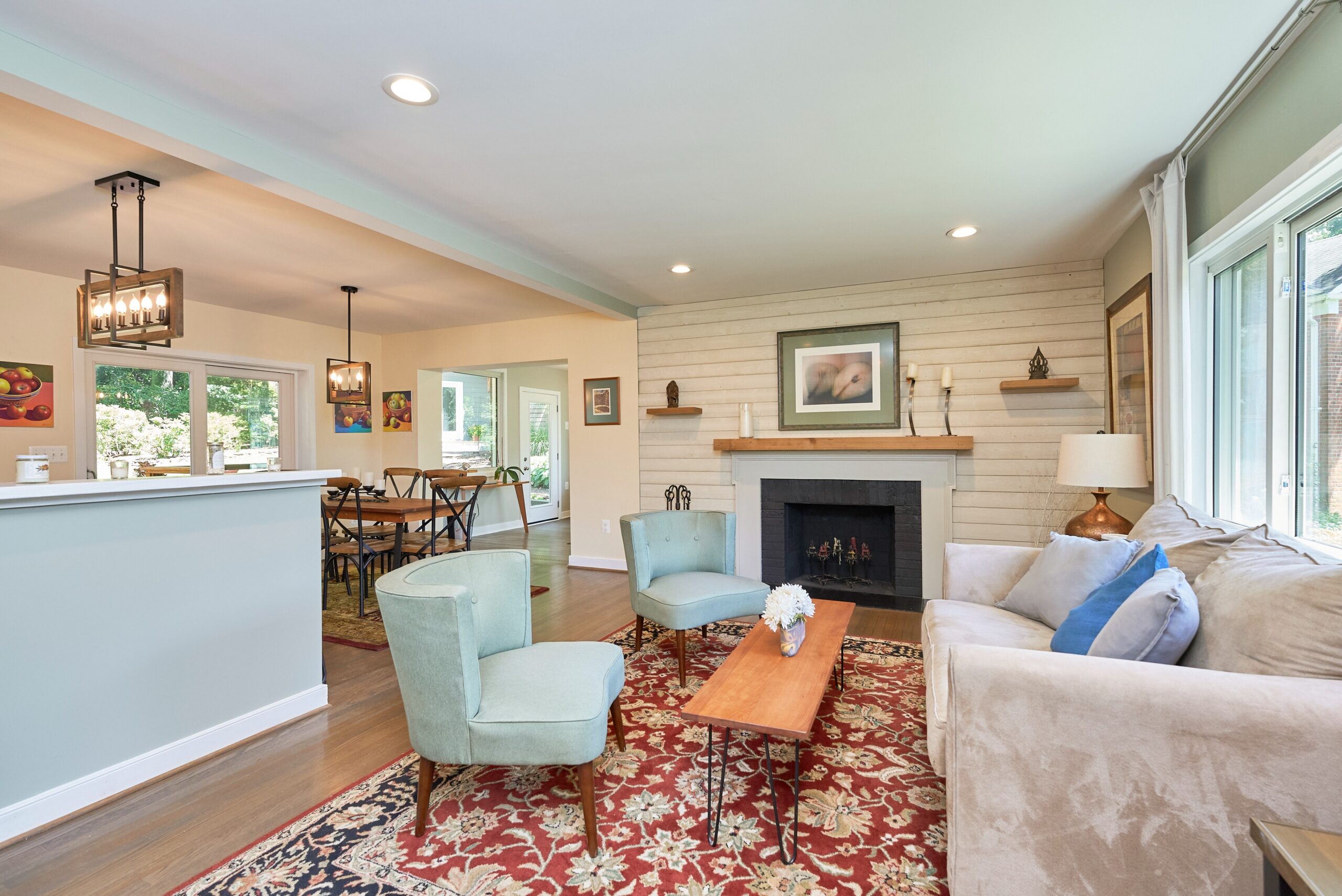 Professional photo of interior of custom home in Falls Church, Virginia. Shows living space with fireplace and dining area in the background.