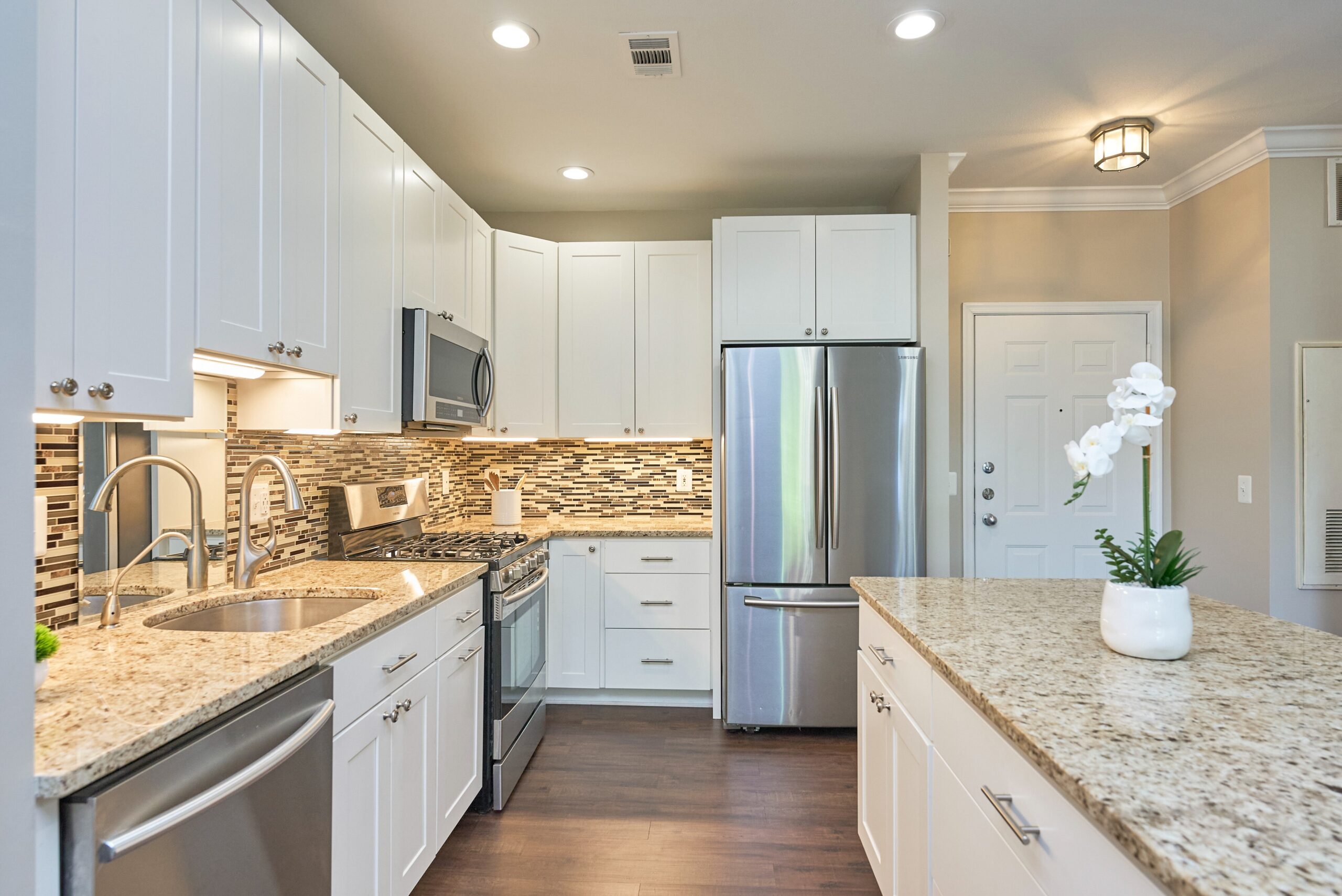 White kitchen with lots of cabinets, upgraded stainless steel appliances, and granite countertops
