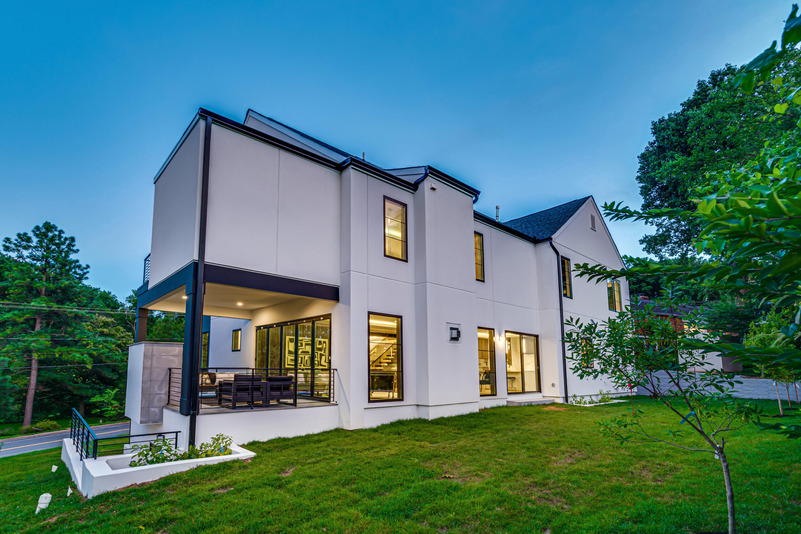 rear exterior view at dusk of modern new construction luxury home in Arlington, Virginia