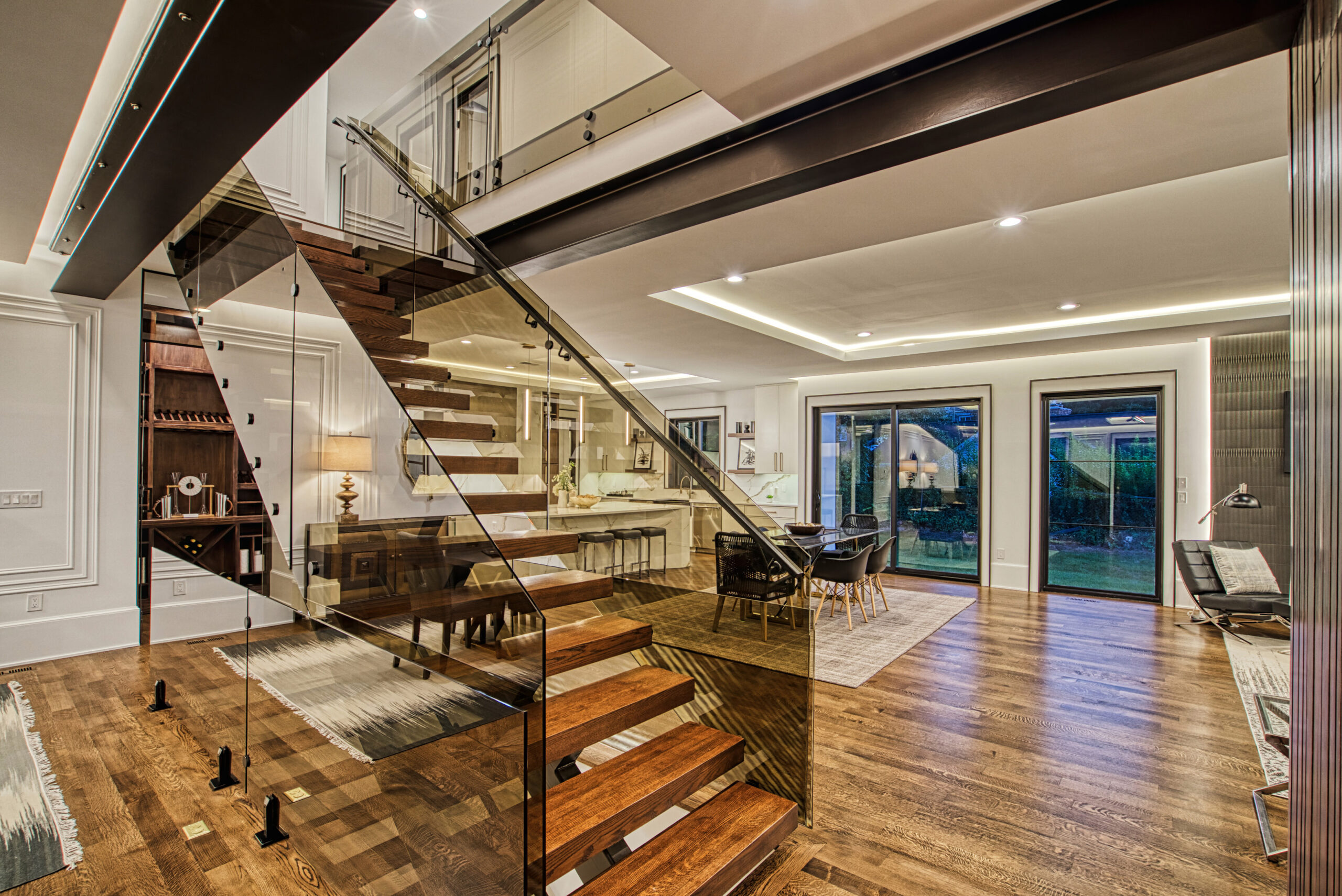interior of new construction luxury home showing floating staircase and custom hardwood floors