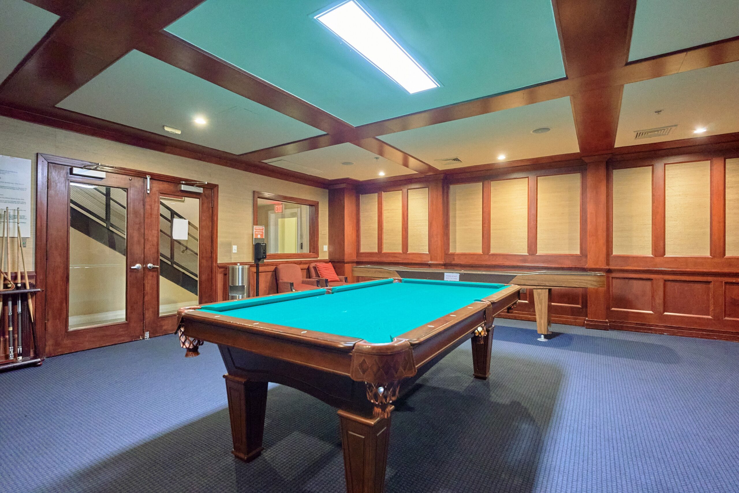 Game room in luxury condo building with billiards table and shuffleboard table visible.