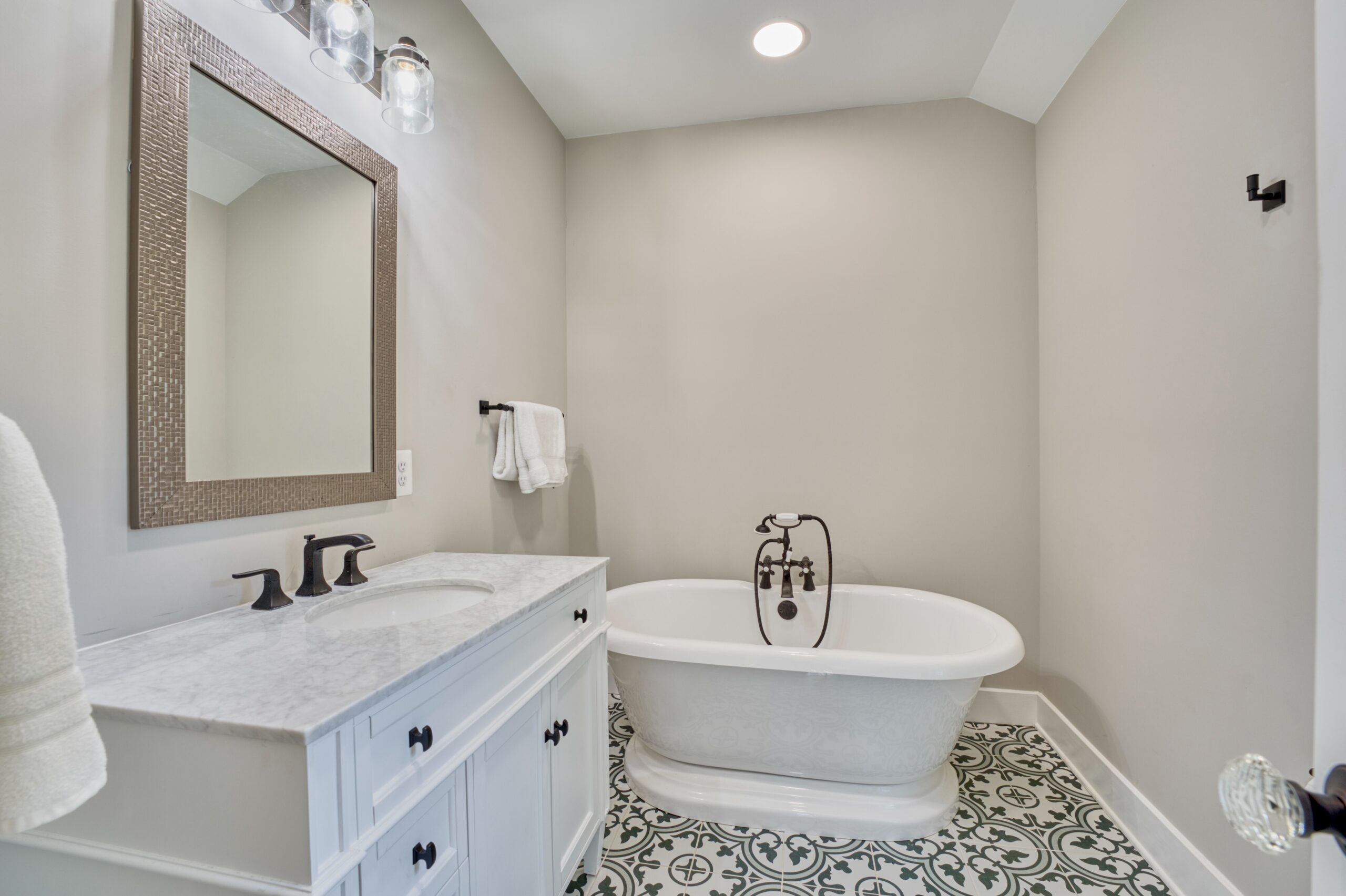 Remodeled bathroom in historic home in Hamilton, VA with intricate black/white tile floors and soaking tub