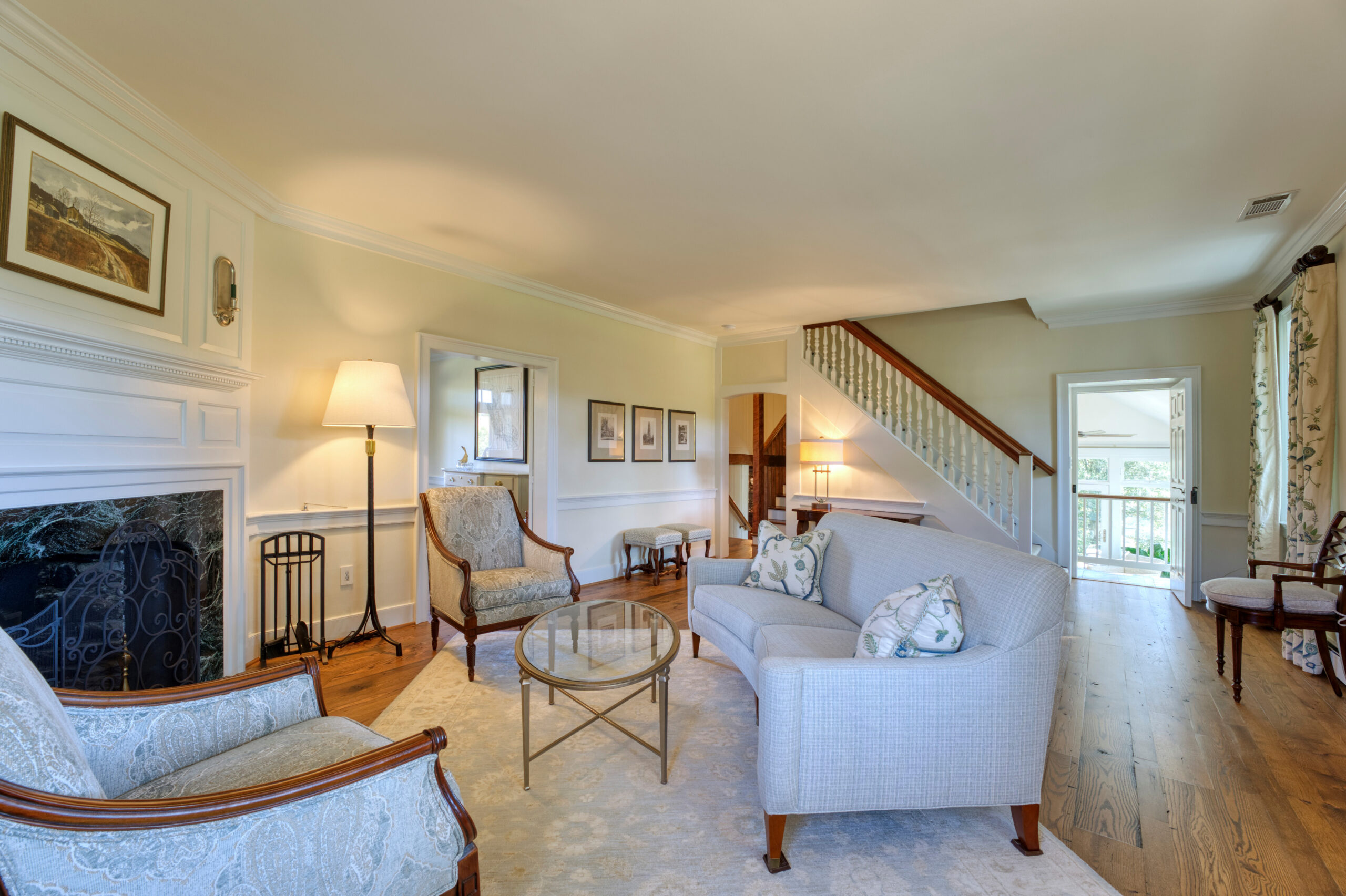Professional interior photo of main house of Historic Hearthstone Manor: 35428 Appalachian Trail Rd, Round Hill, Virginia - showing formal living room with fireplace and staircases in the background