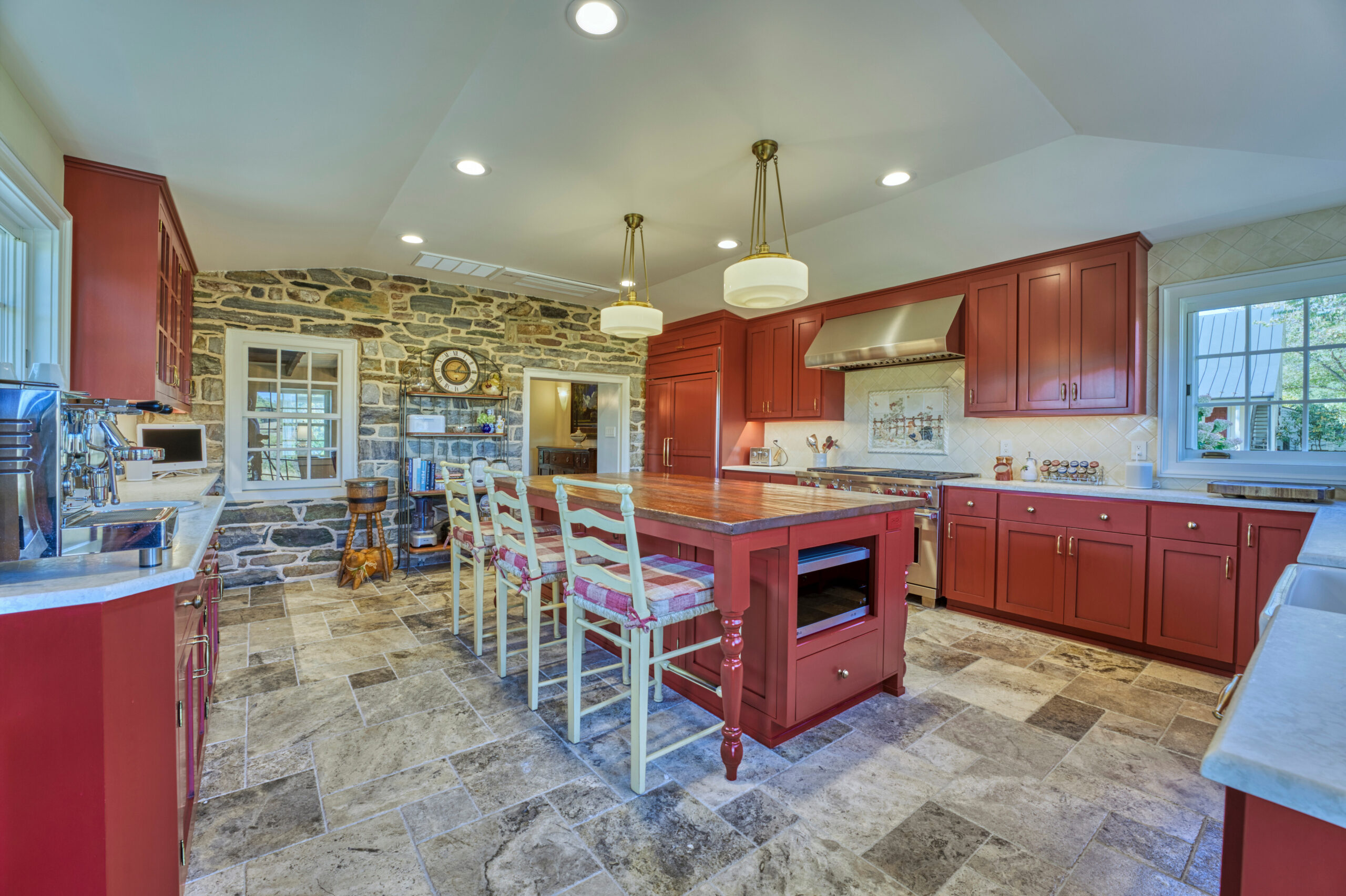 Professional interior photo of main house of Historic Hearthstone Manor: 35428 Appalachian Trail Rd, Round Hill, Virginia - showing large kitchen with stone accent wall, large center island with barstools, brick red and white color scheme