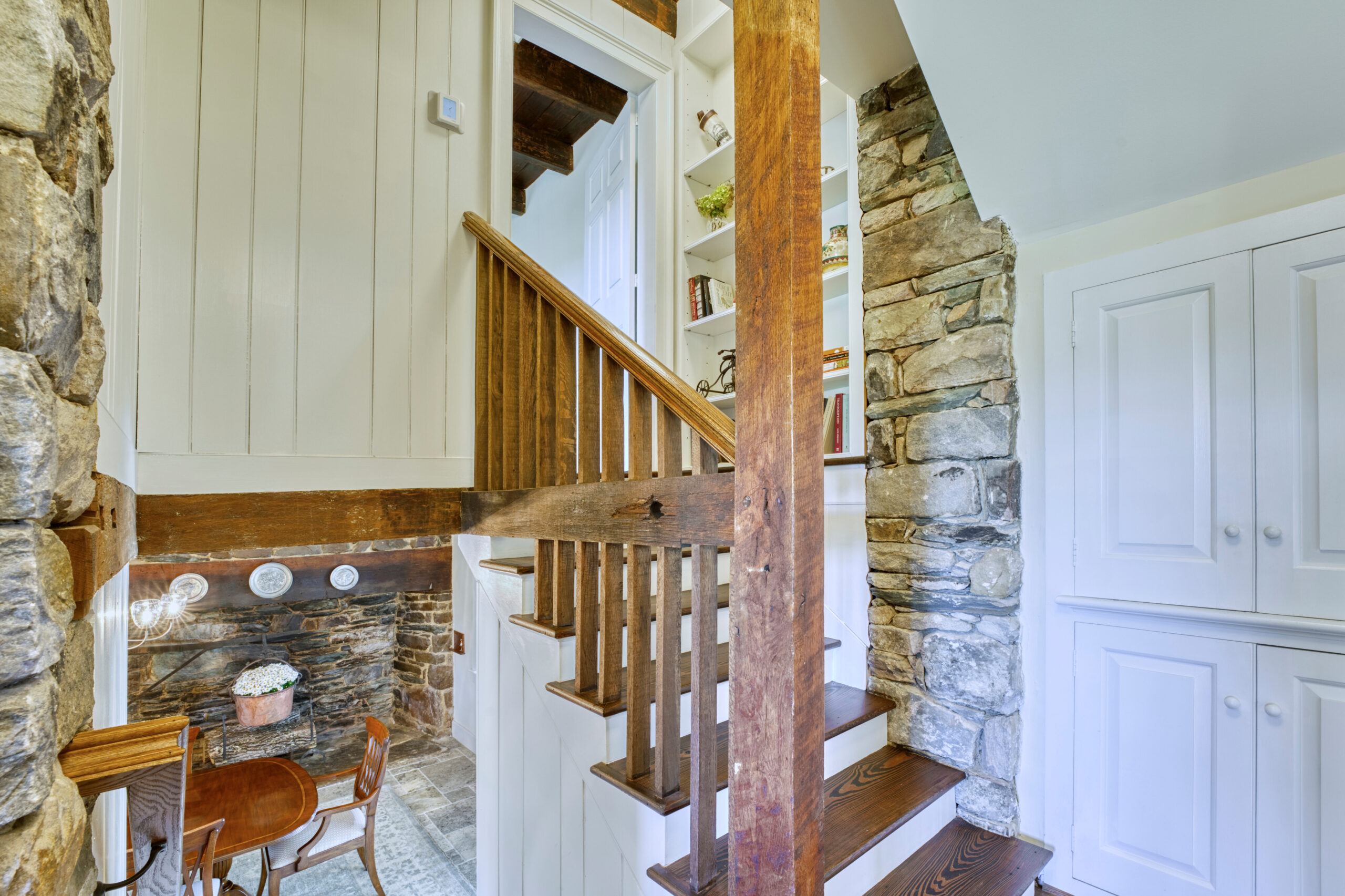 Professional interior photo of main house of Historic Hearthstone Manor: 35428 Appalachian Trail Rd, Round Hill, Virginia - showing staircase going up a split level, glimpse of formal dining room below