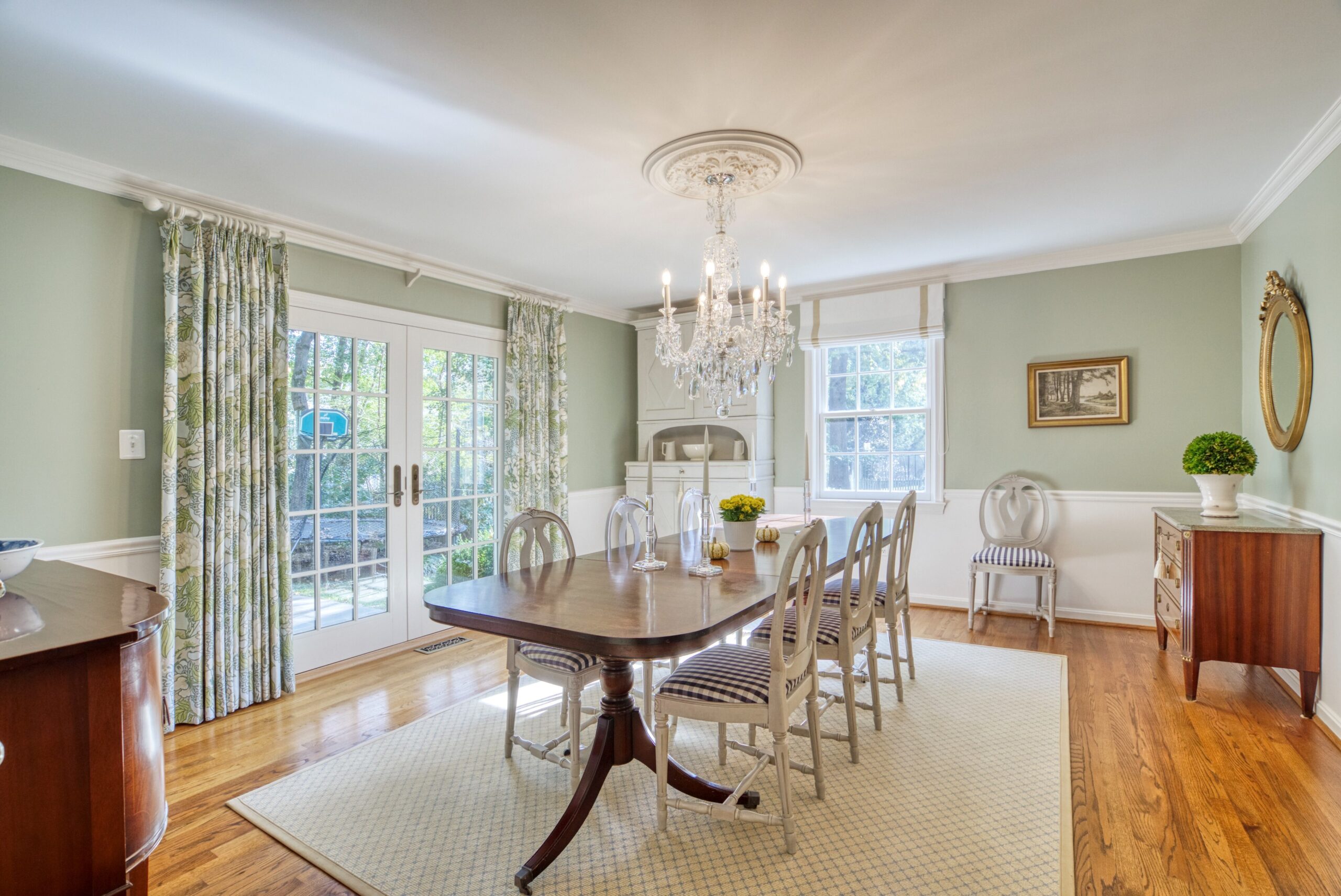 Professional interior photo of 8305 River Falls Dr, Potomac, MD - showing formal dining room with chanedlier, hardwood floors, and mint green and off white colors