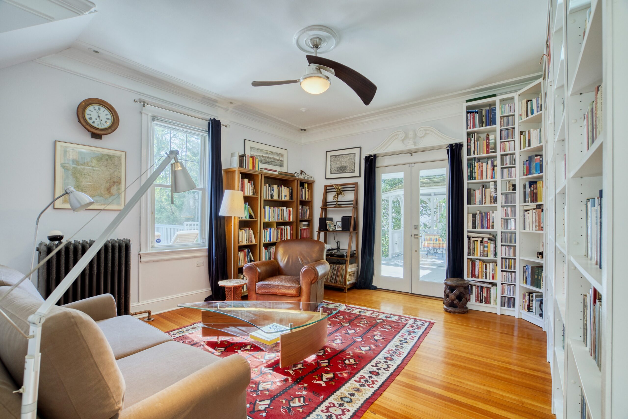 Interior professional photo of 1826 Varnum St NW - showing a study with built-in, floor-to-ceiling bookshelves, hardwood floors and antique radiator