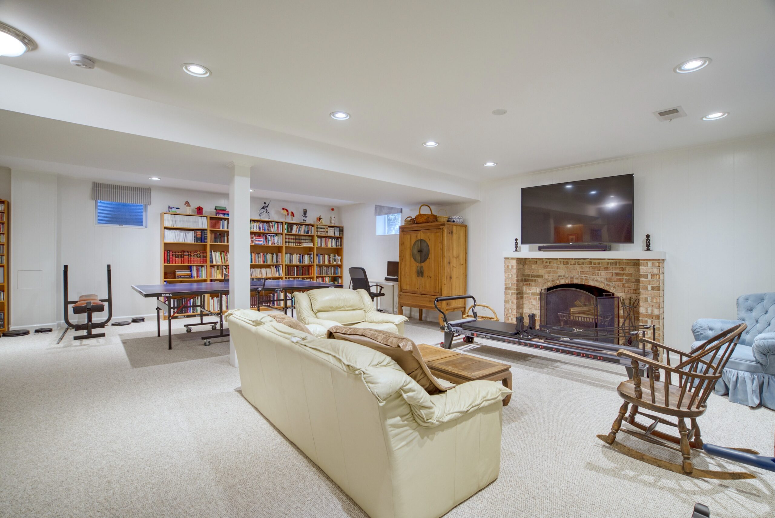 Professional interior photo of 8305 River Falls Dr, Potomac, MD - showing basement living room with fireplace