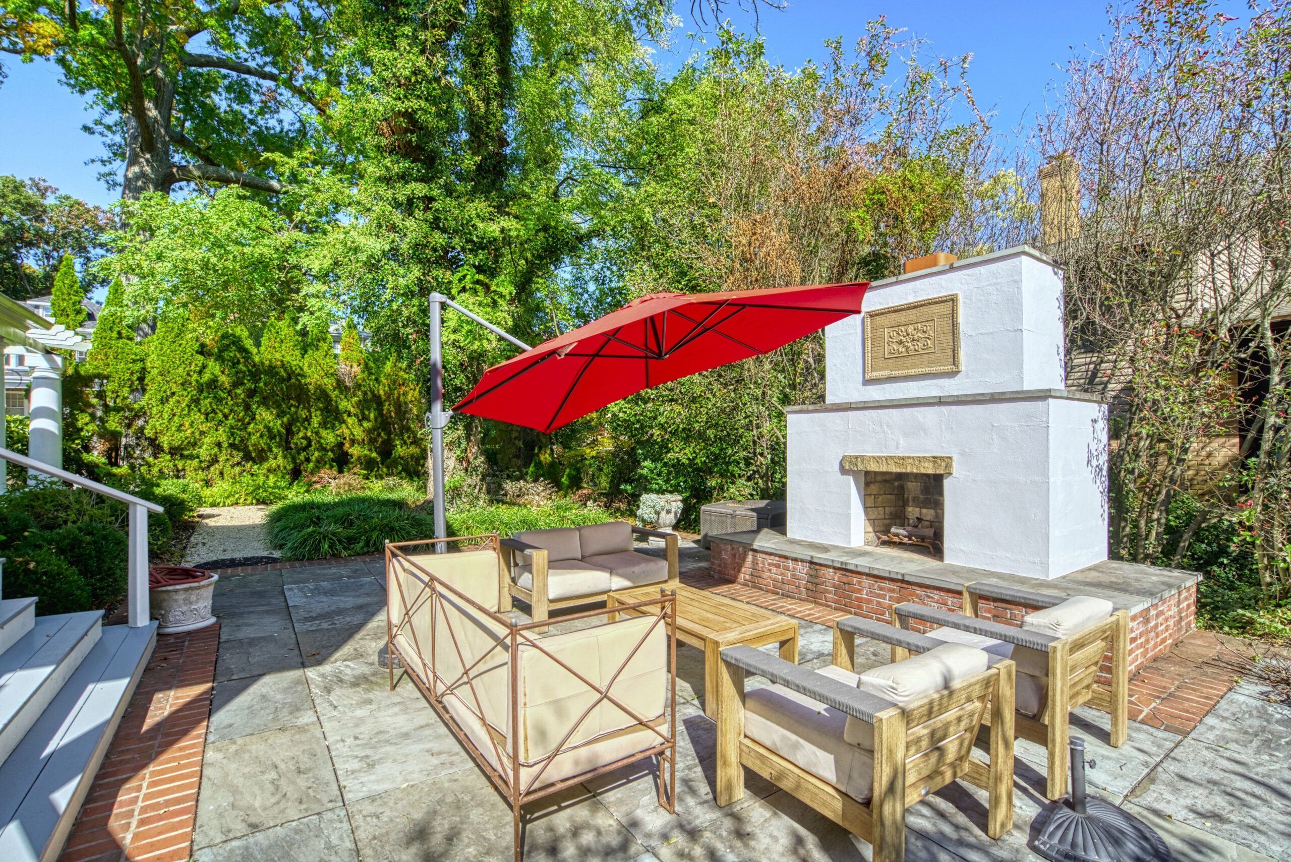 Exterior professional photo of 1826 Varnum St NW - showing the rear flagstone patio and large fireplace by patio furniture