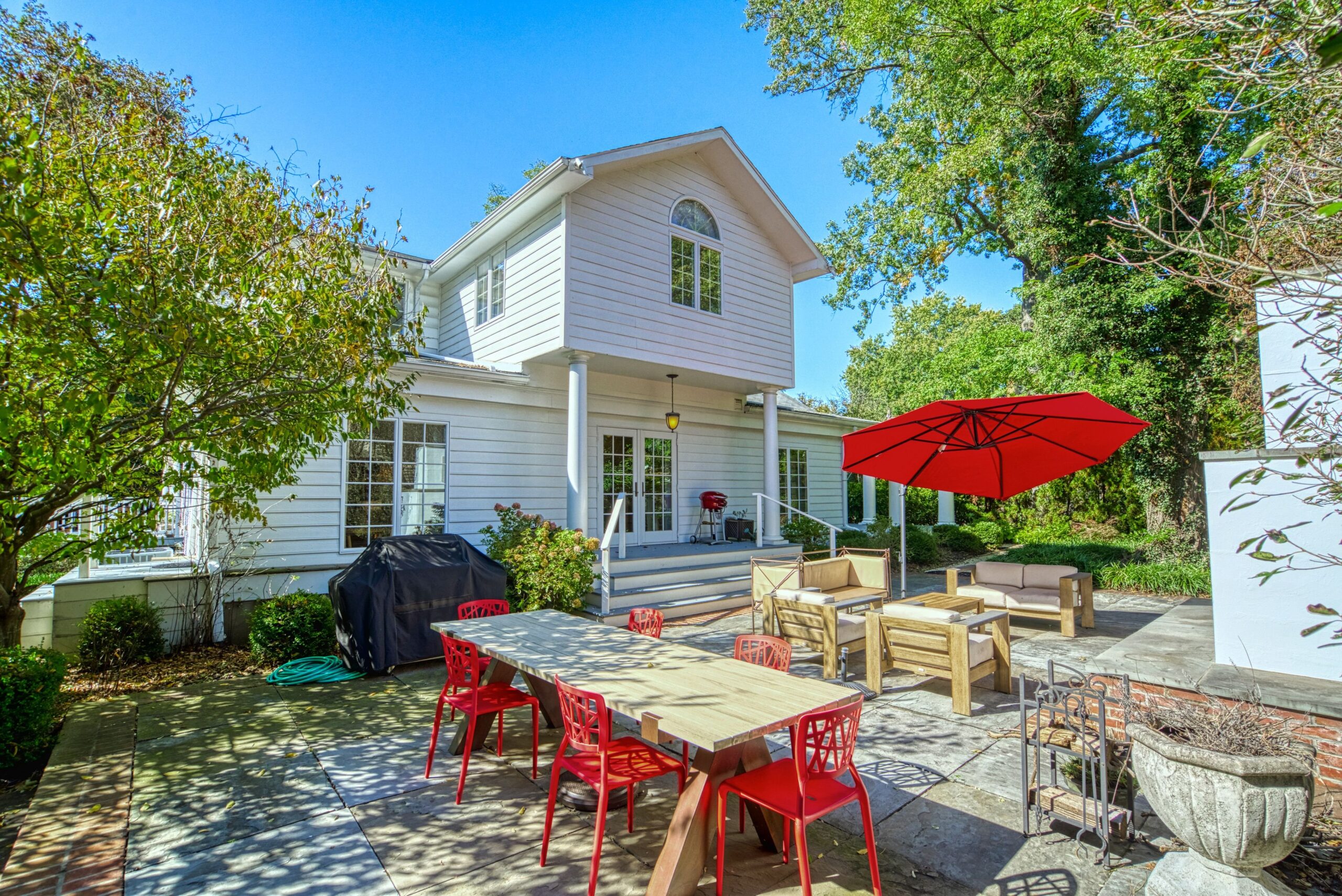 Exterior professional photo of 1826 Varnum St NW - showing the rear flagstone patio with patio furniture and red umbrella 