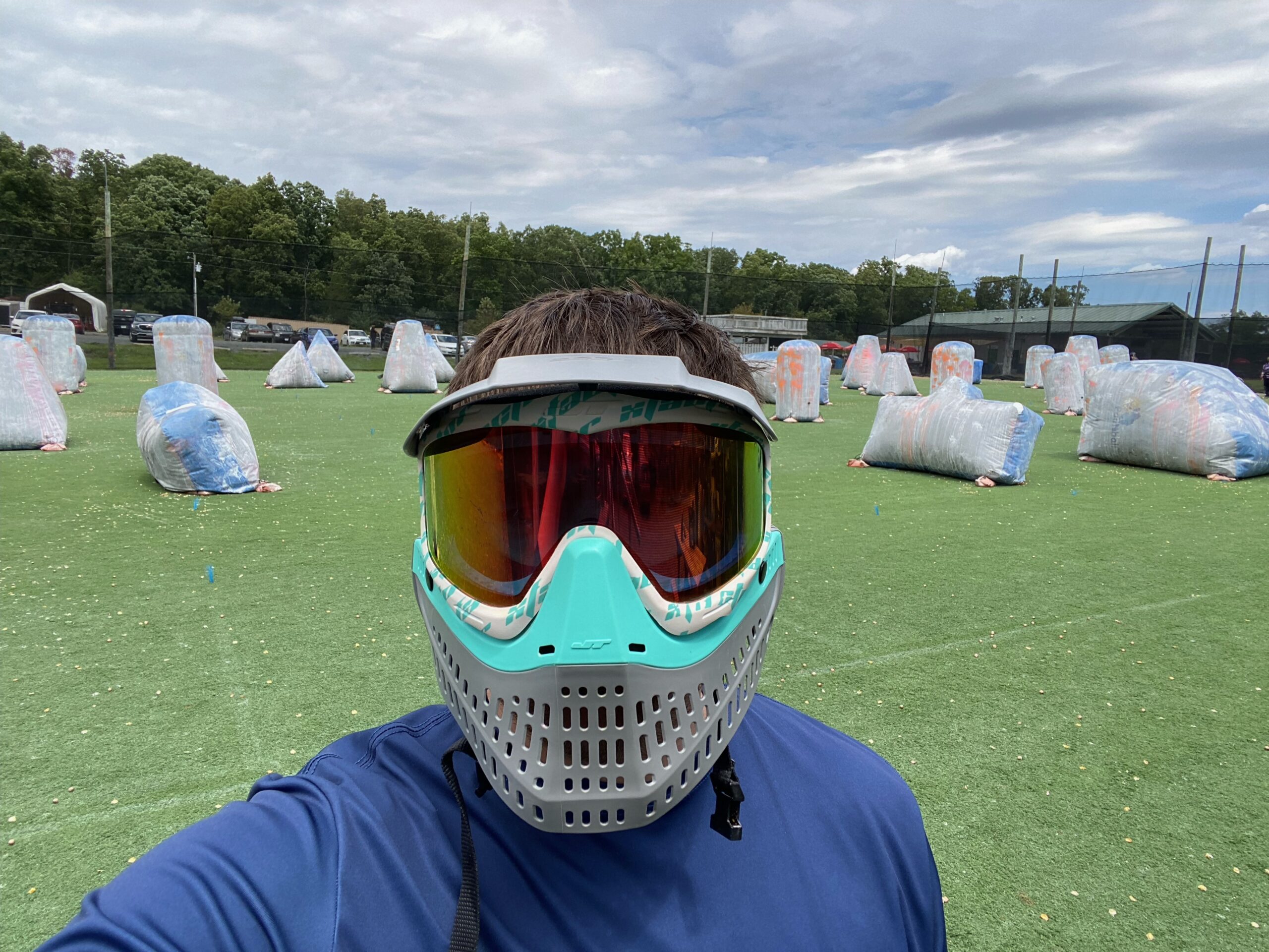 Sean Conroy, Photographer with Sky Blue Media, wearing goggles and a mask at a paintball ground