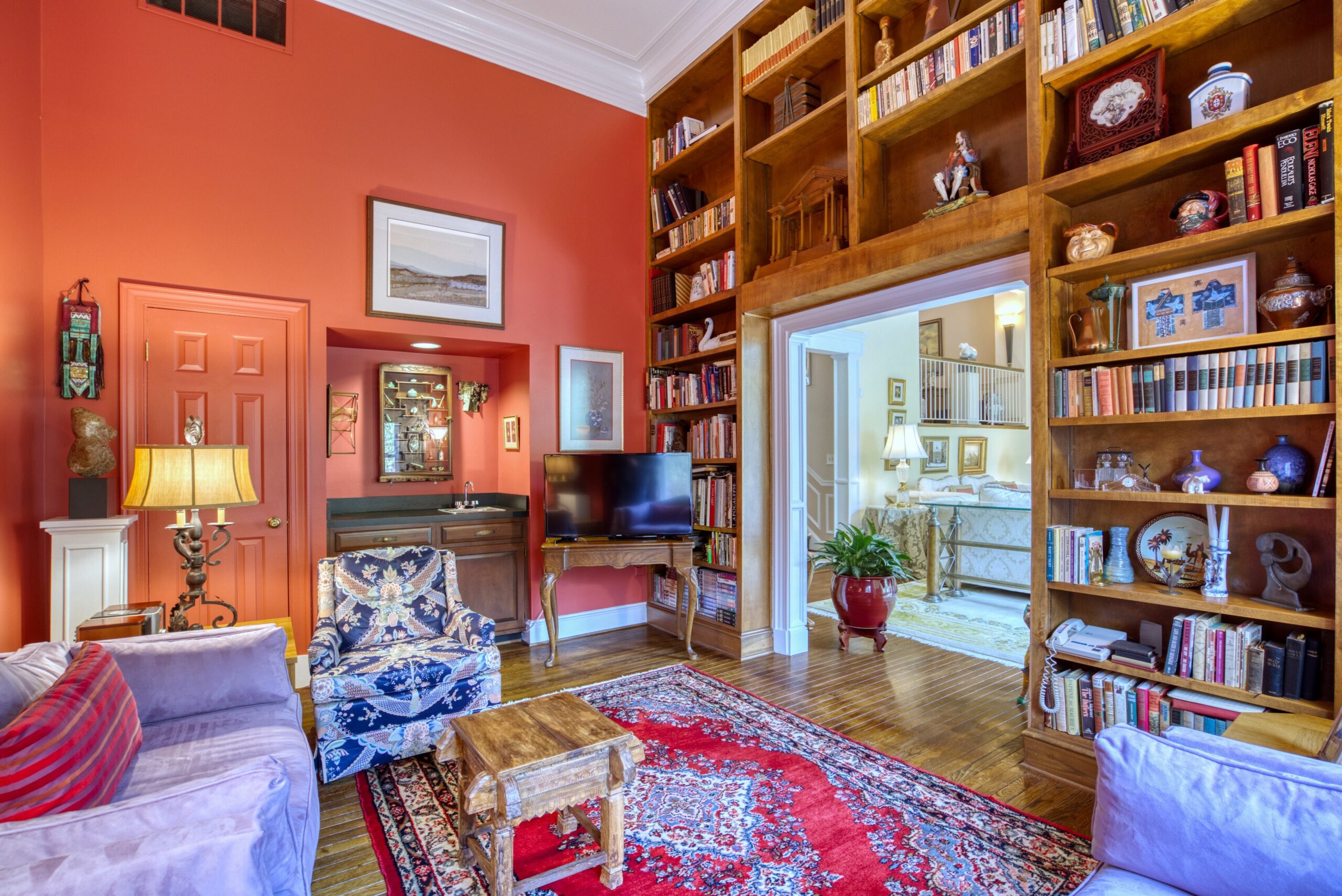 Interior professional photo of 1324 Skipwith Road - showing the study with a floor-to-ceiling built in wall of wooden bookshelves 