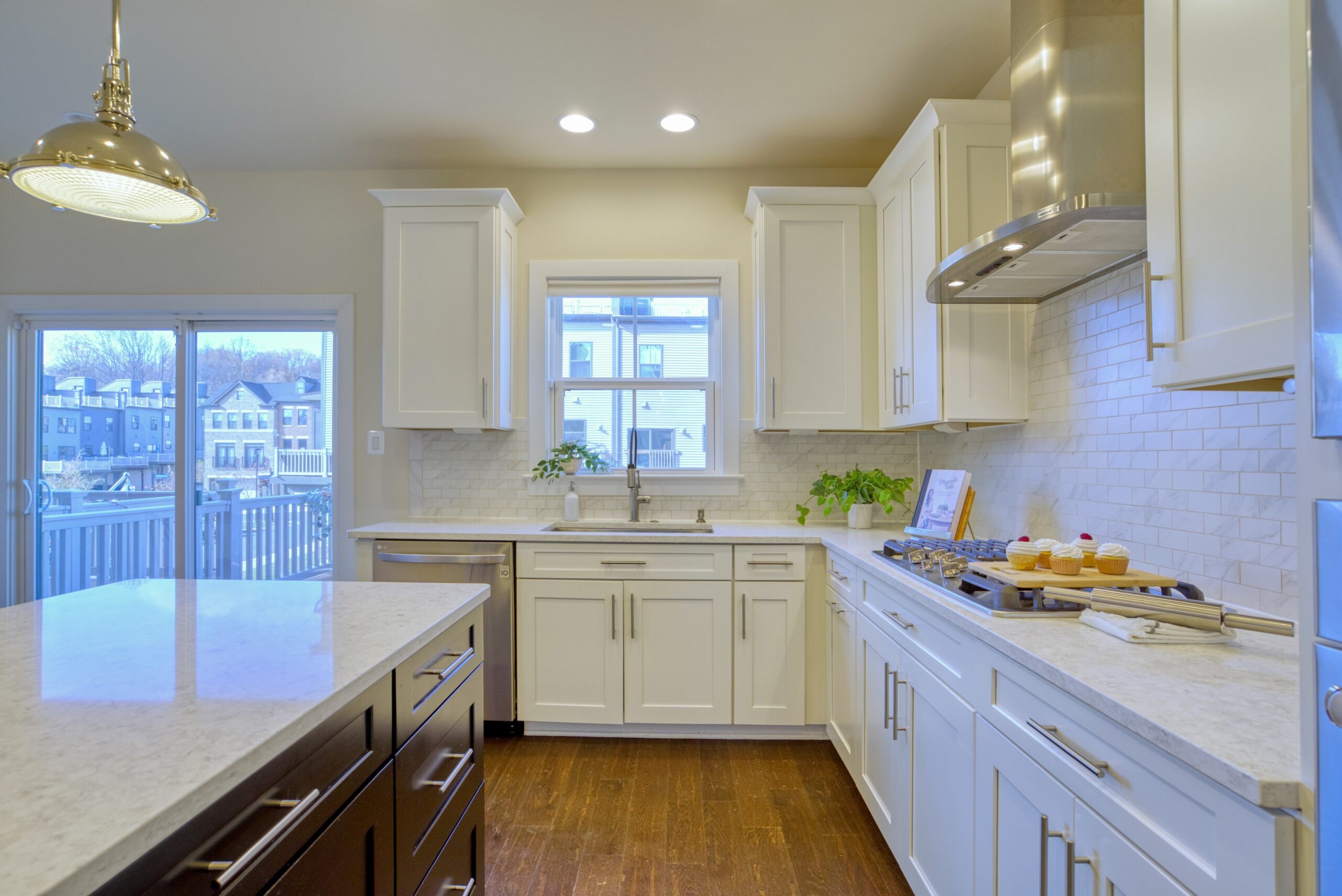 Professional interior photo of 3165 Virginia Bluebell Ct, Fairfax - showing the white kitchen and large island from an angle with view towards the rear windows