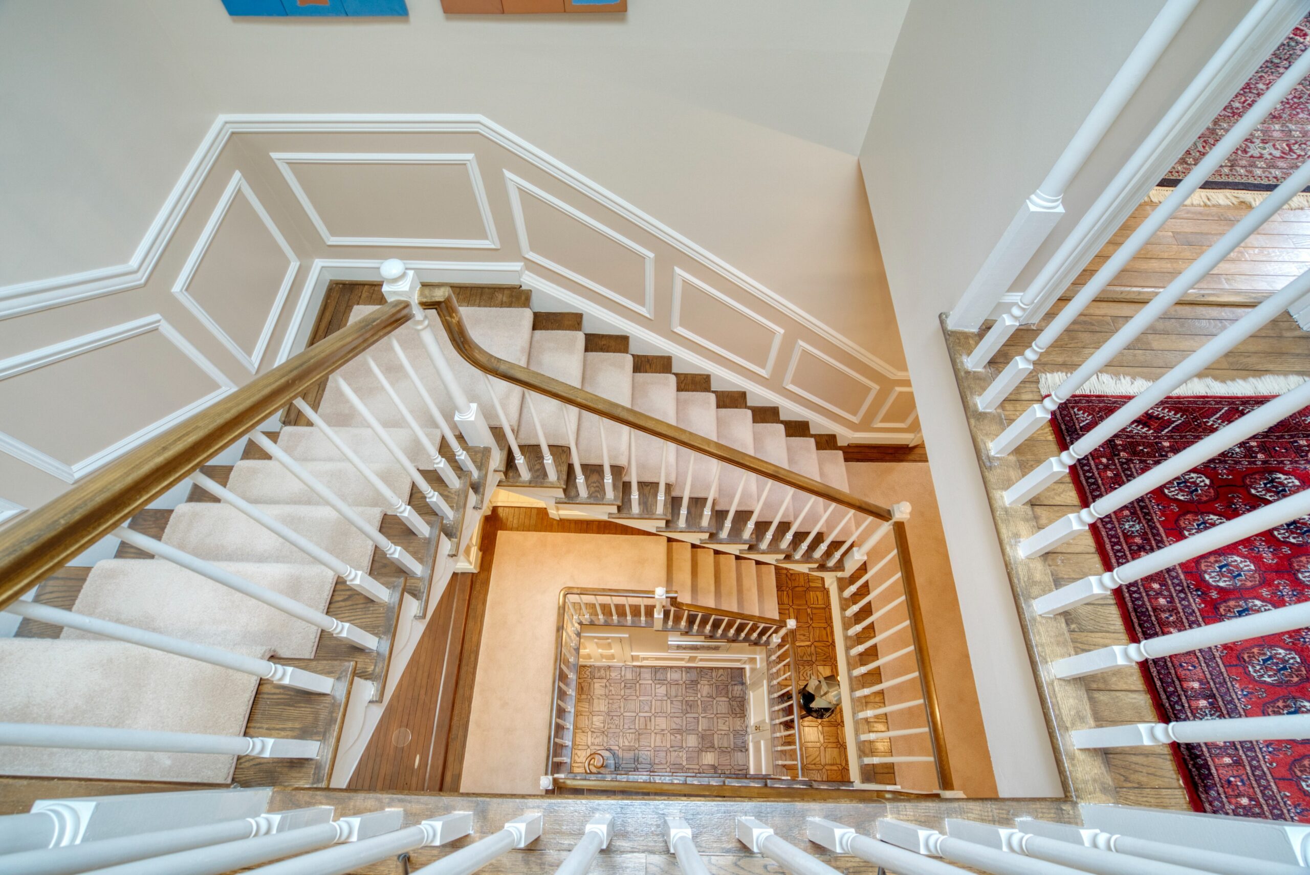 Interior professional photo of 1324 Skipwith Road - looking straight down the center of the home's spiral staircase