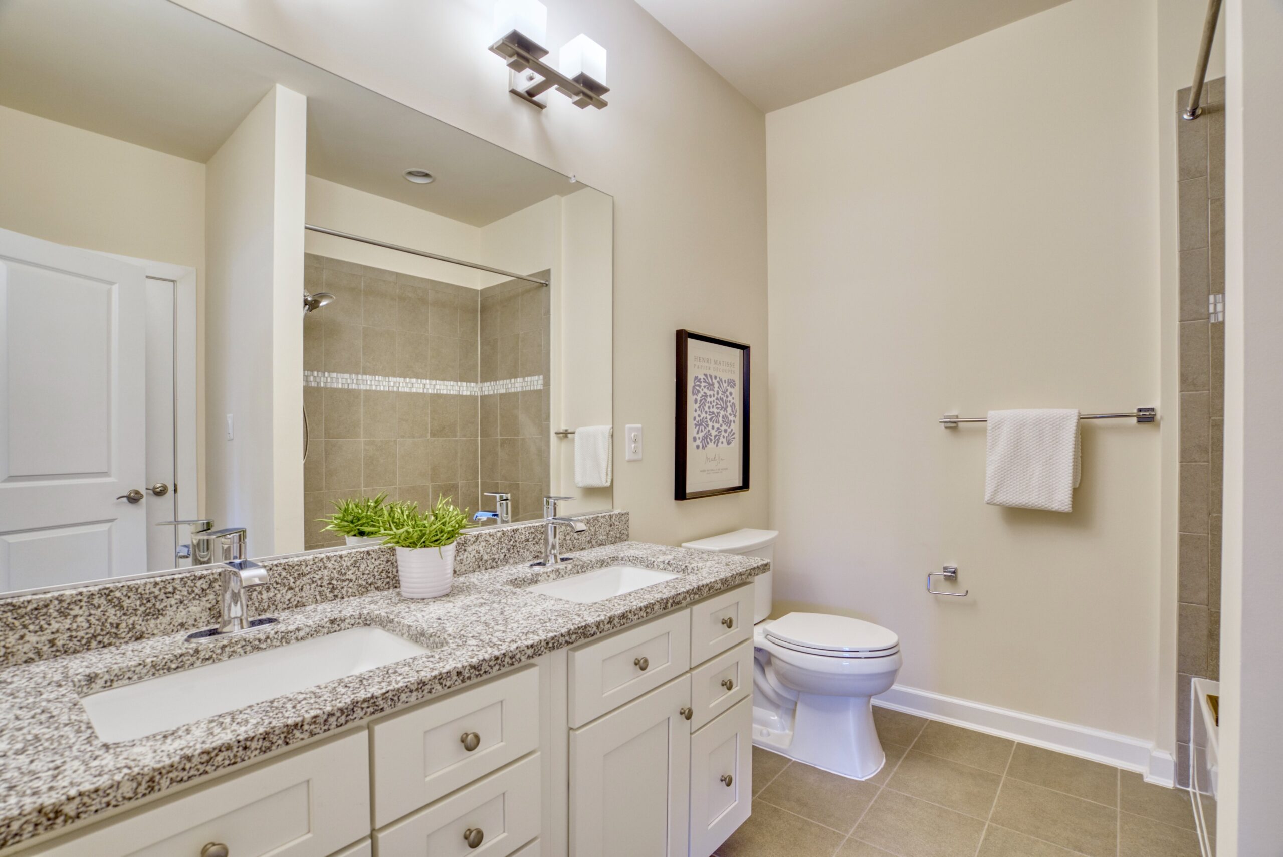 Professional interior photo of 3165 Virginia Bluebell Ct, Fairfax - showing a full bathroom with granite counters and dual vanity with fully tiled shower reflecting in the mirror