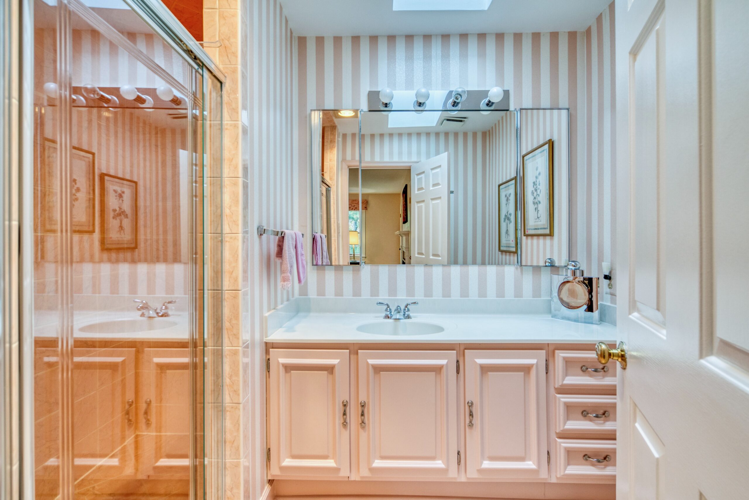 Interior professional photo of 1324 Skipwith Road - showing a full bathroom in antique pink cabinets, and white and pink wallpaper