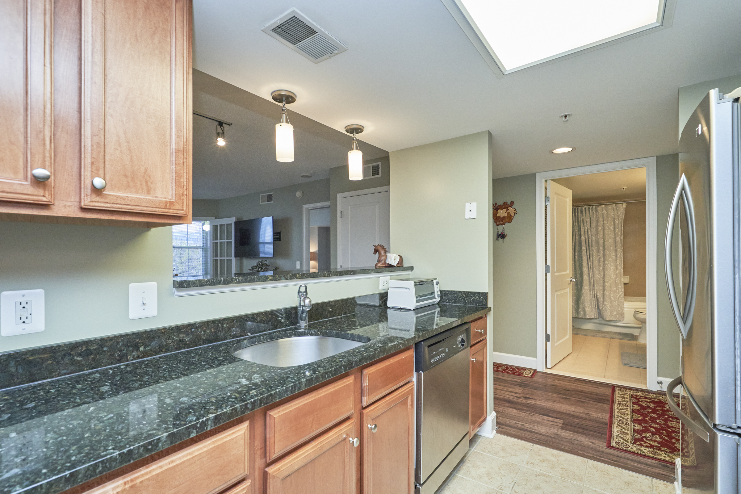 Interior professional photo of 11800 Sunset Hills Road Unit #811, showing the kitchen from the perspective of looking out to the hall or through the picture window to the living area