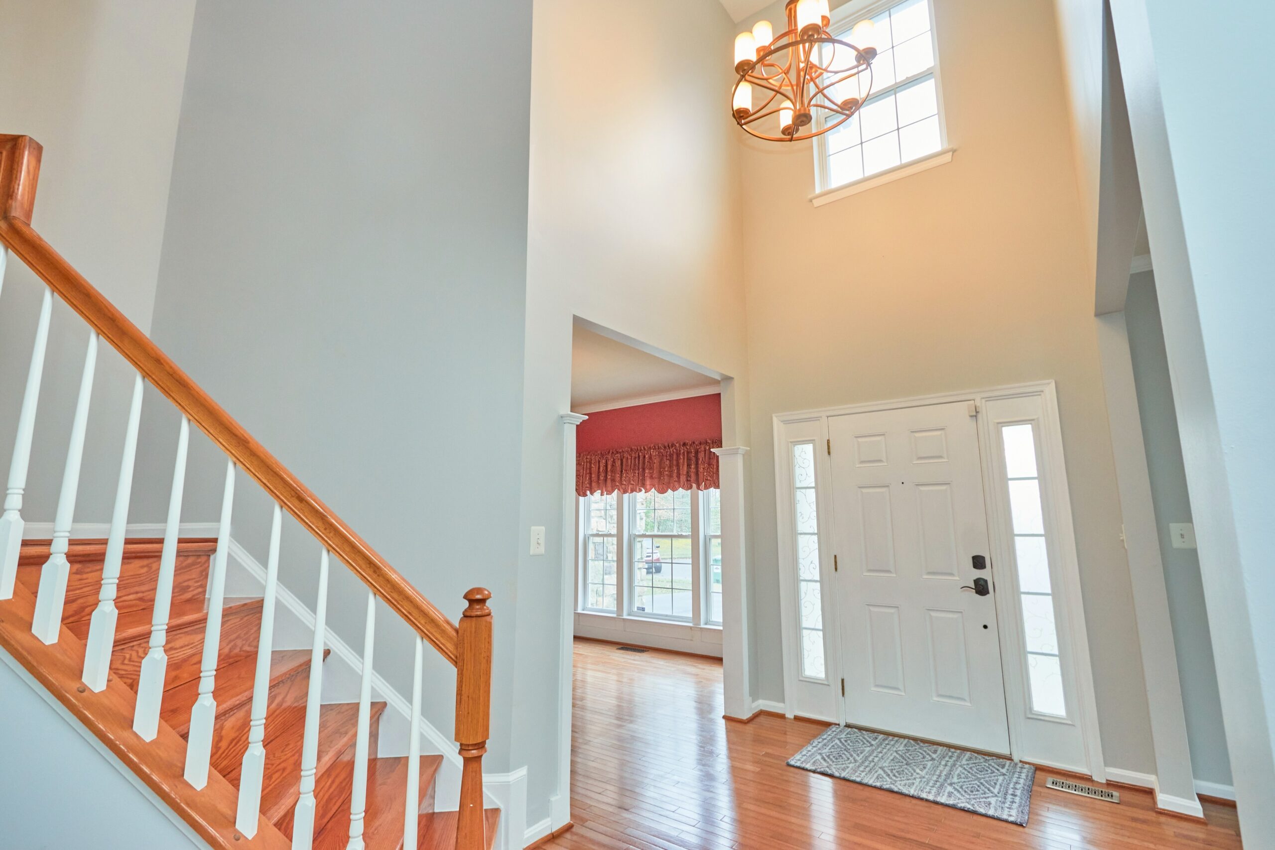 Professional interior photo of 80 Brentsmill Drive in Stafford, Virginia - showing the front 2-story entry with staircase on the left and chandelier