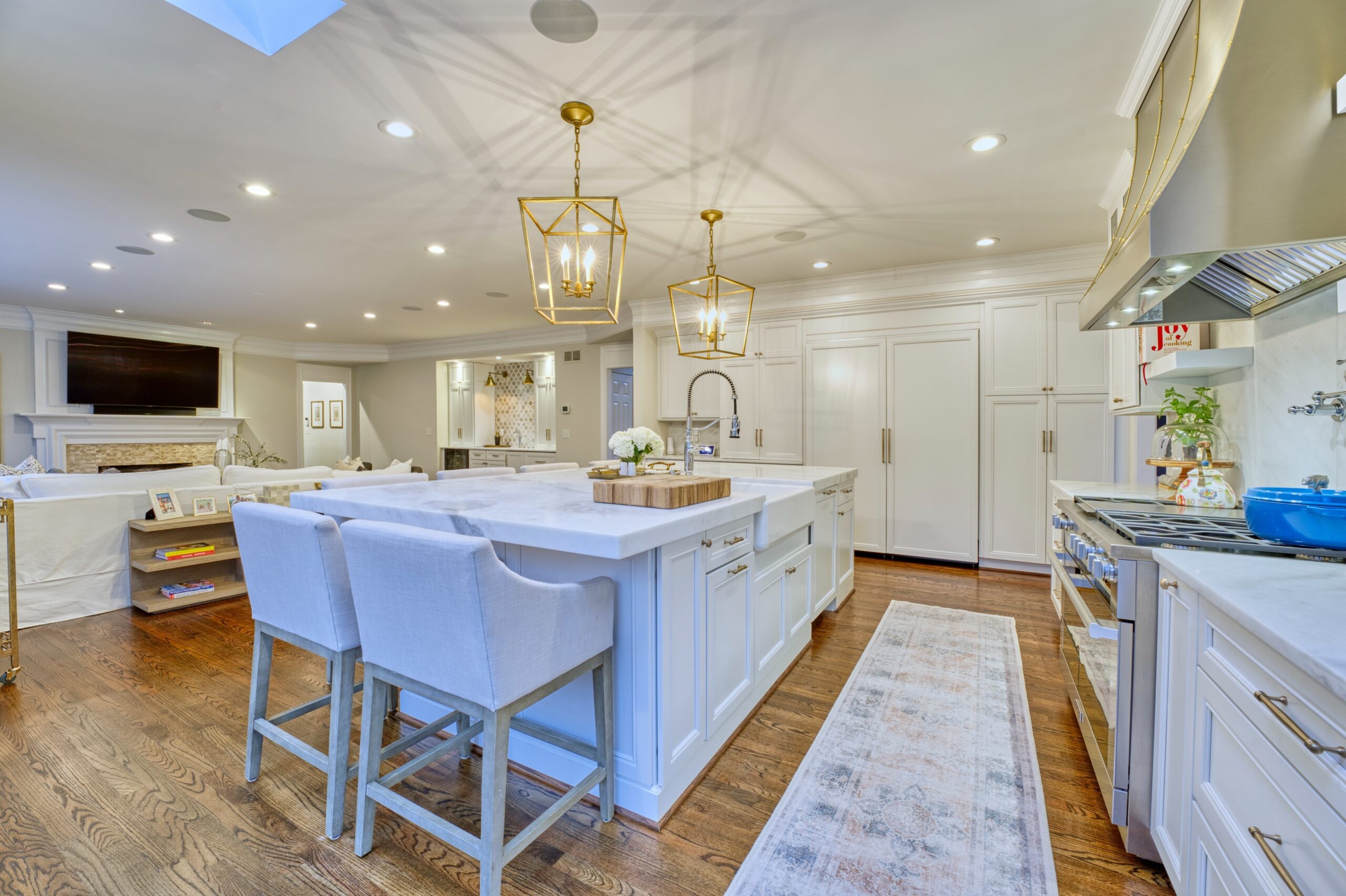 Professional interior photo of 47572 Compton Circle, Sterling, VA - showing the large open kitchen and island flowing into the family room bordered by a wetbar