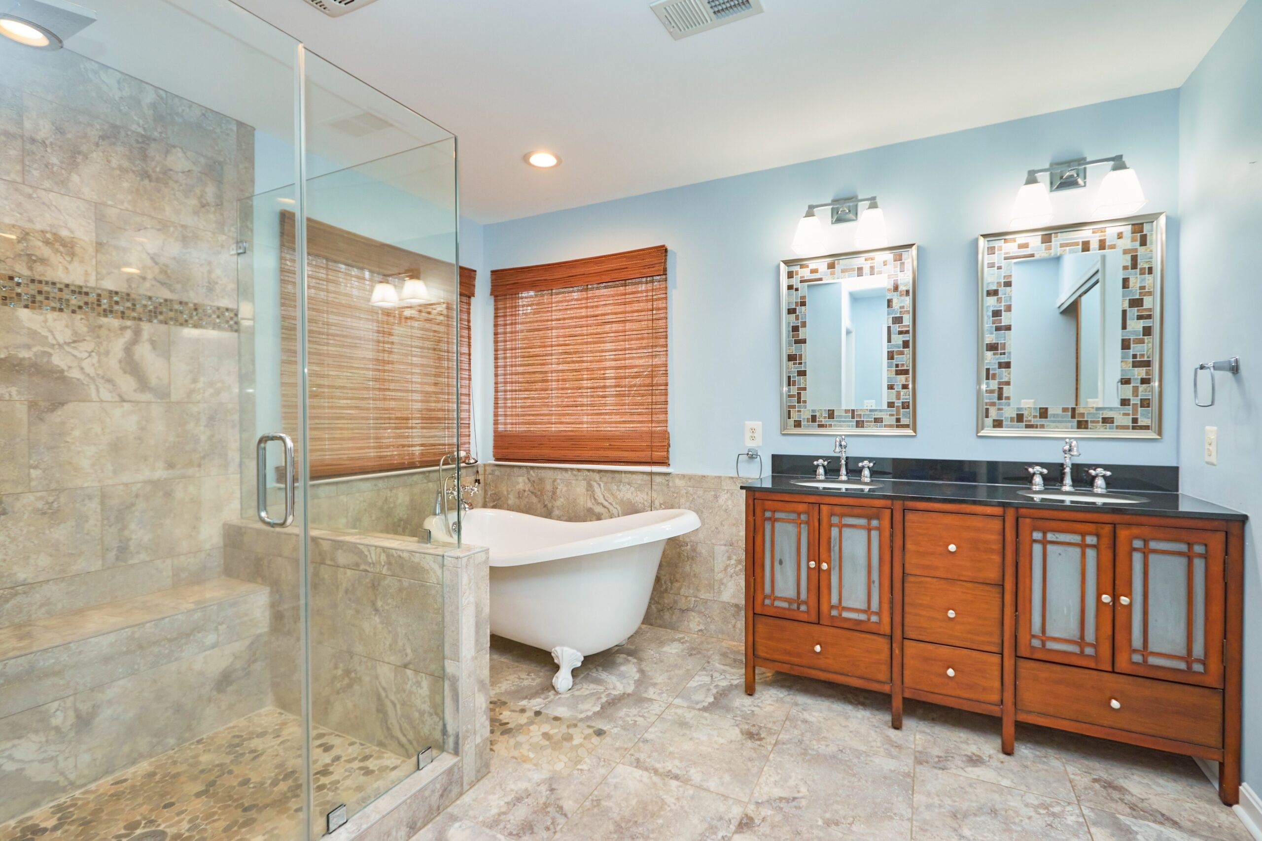 Professional interior photo of 80 Brentsmill Drive in Stafford, Virginia - showing the master bathroom with large stone shower and white claw bathtub