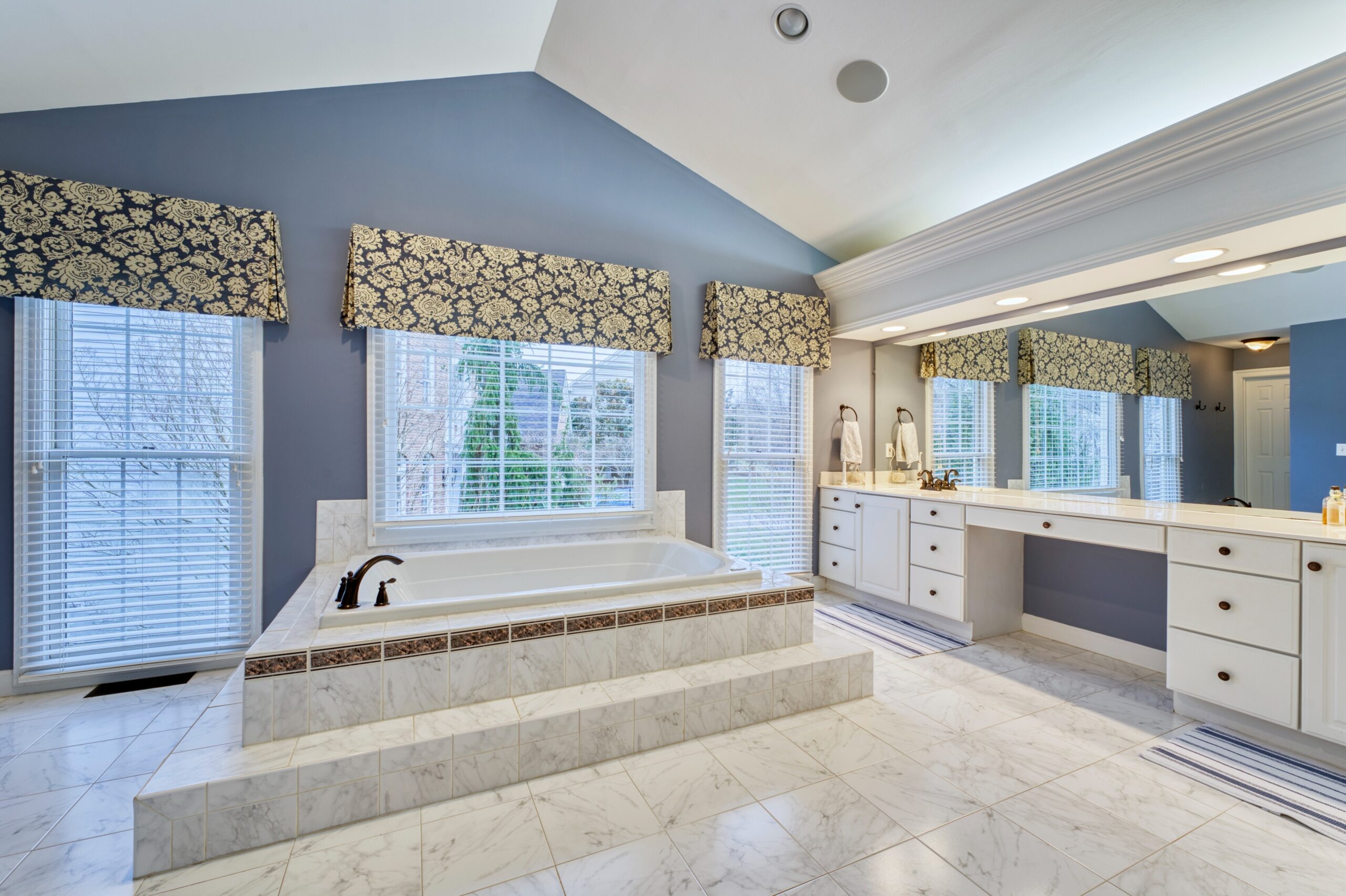 Professional interior photo of 47572 Compton Circle, Sterling, VA - showing the primary bathroom with a large tub in the center of the room against the windows
