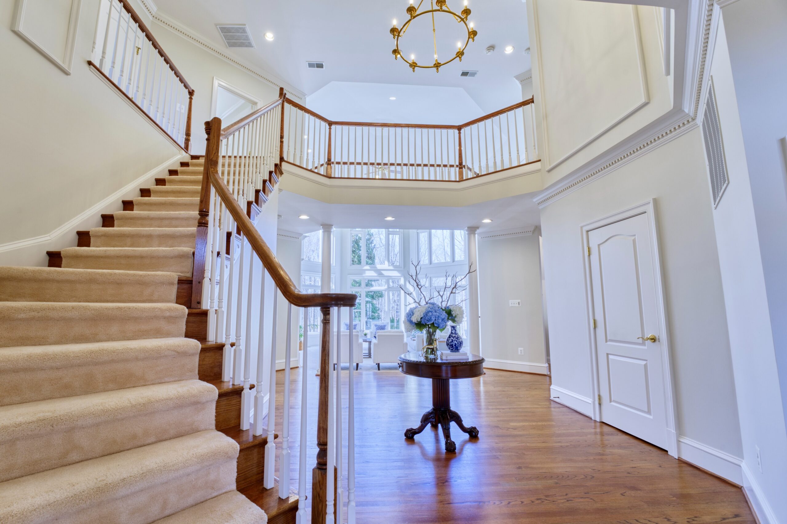 Professional interior photo of 17087 Bold Venture Drive, Leesburg - showing the foyer looking up towards the secont floor and through to the living room. 