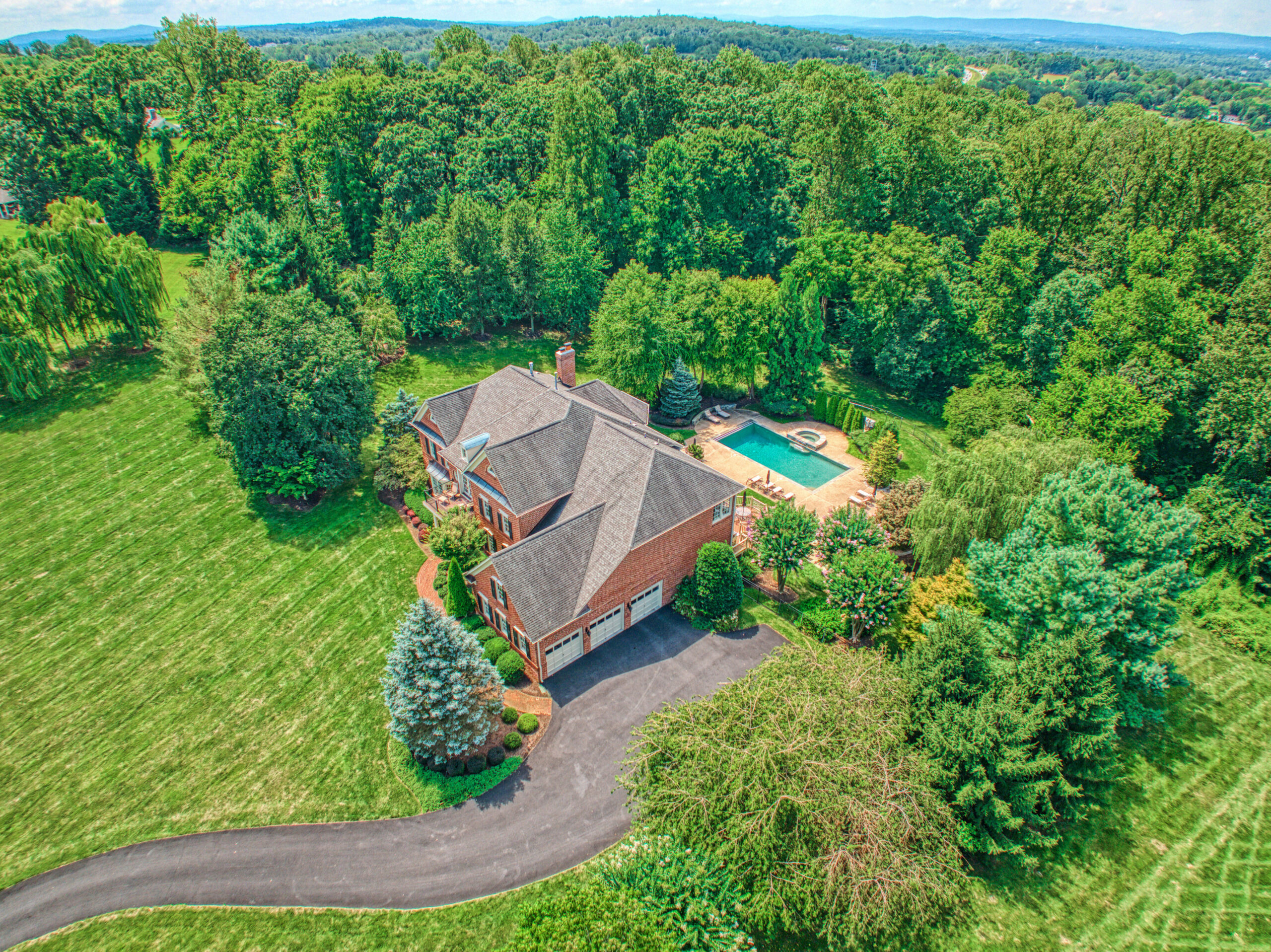 Professional exterior photo of 17087 Bold Venture Drive, Leesburg - aerial shot showing the house from the garage side with pool visible behind the home