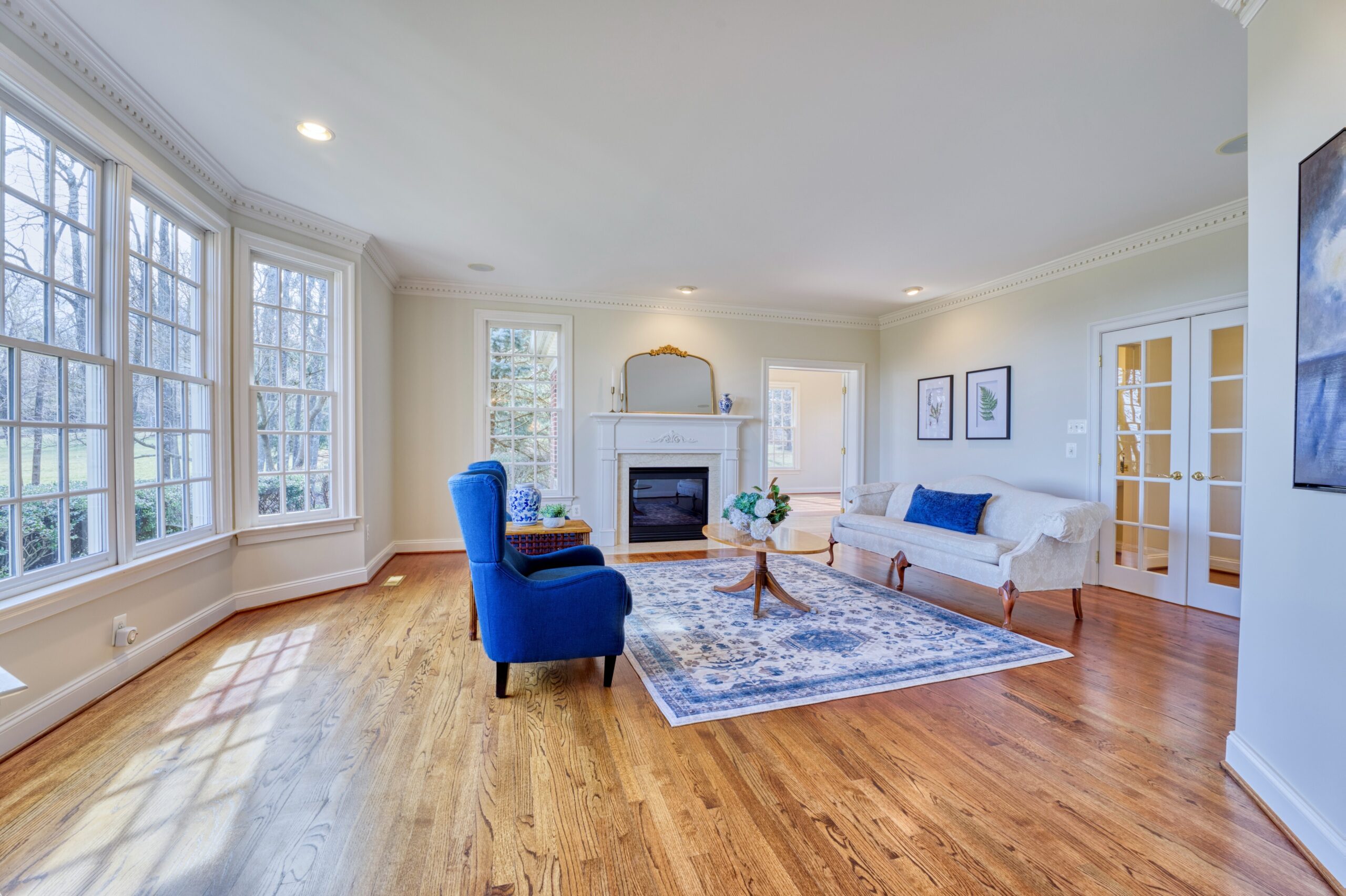 Professional interior photo of 17087 Bold Venture Drive, Leesburg - showing the formal living room with hardwood floors and fireplace