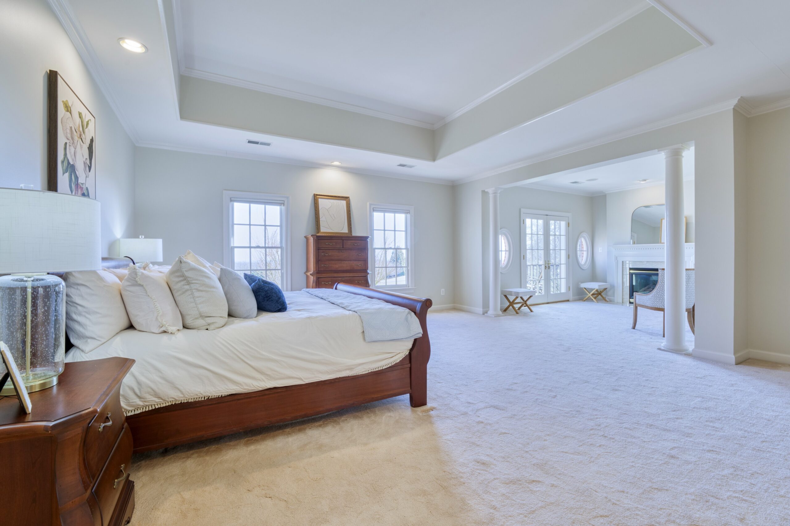 Professional interior photo of 17087 Bold Venture Drive, Leesburg - showing the primary suite with deep tray ceiling and view of the private sitting area with fireplace