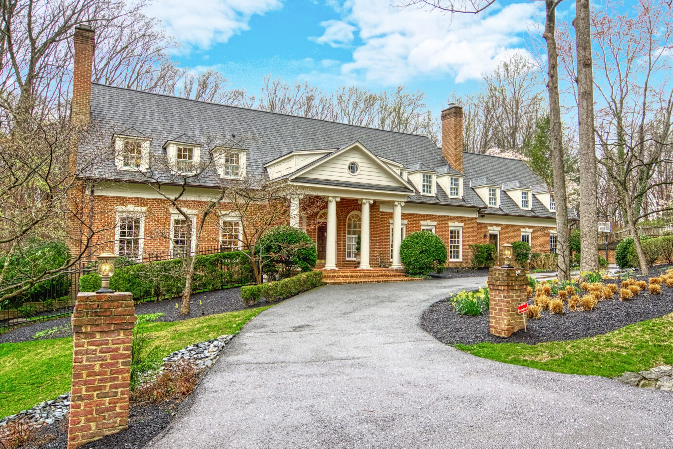 Professional exterior photo of 718 Potomac Knolls Dr - showing the front view from the curb, all-brick home with Georgian columns at the front porch