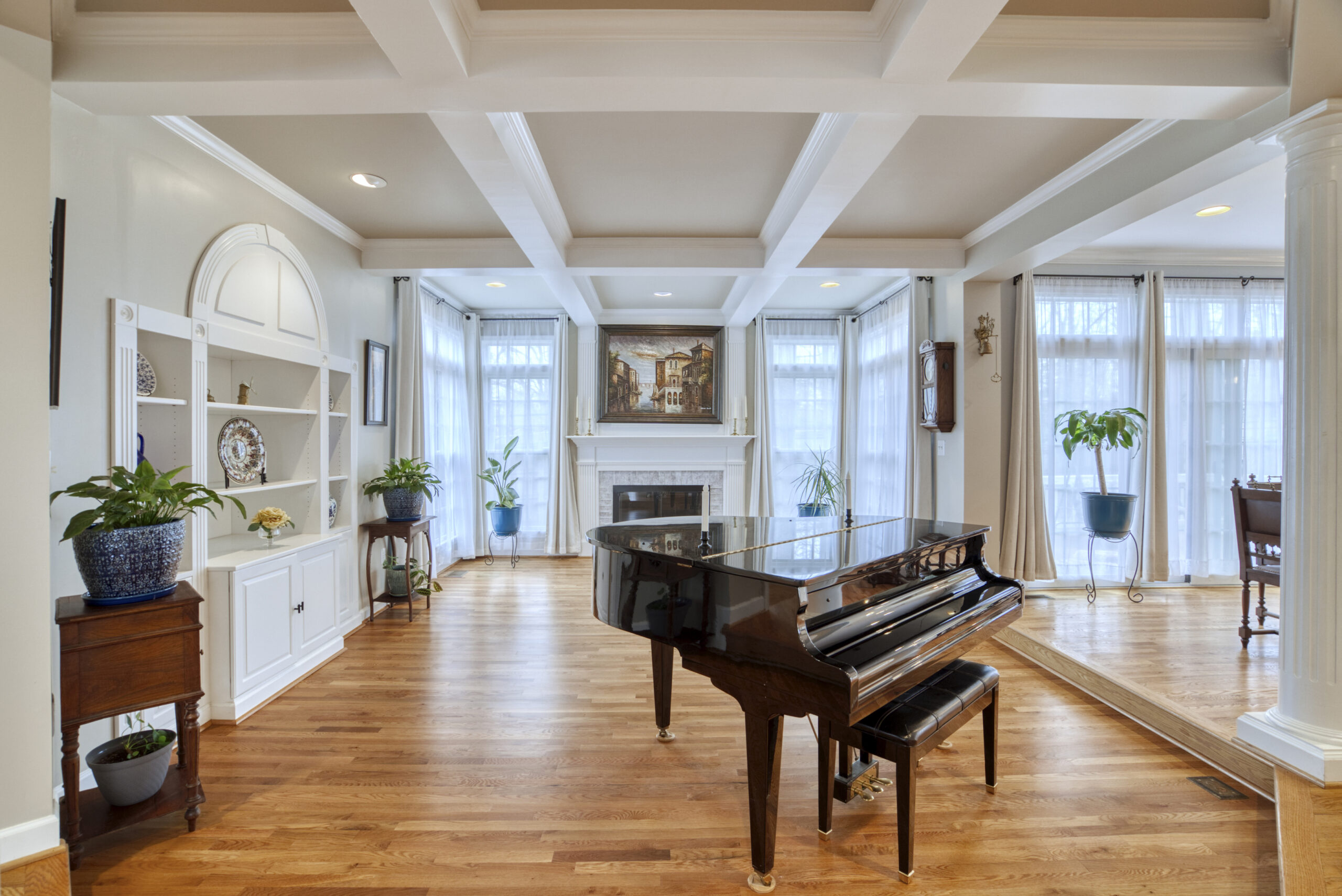Professional interior photo of 9701 Chilcott Manor Way - showing the piano room/conservatory with built in shelves and coffered ceiling