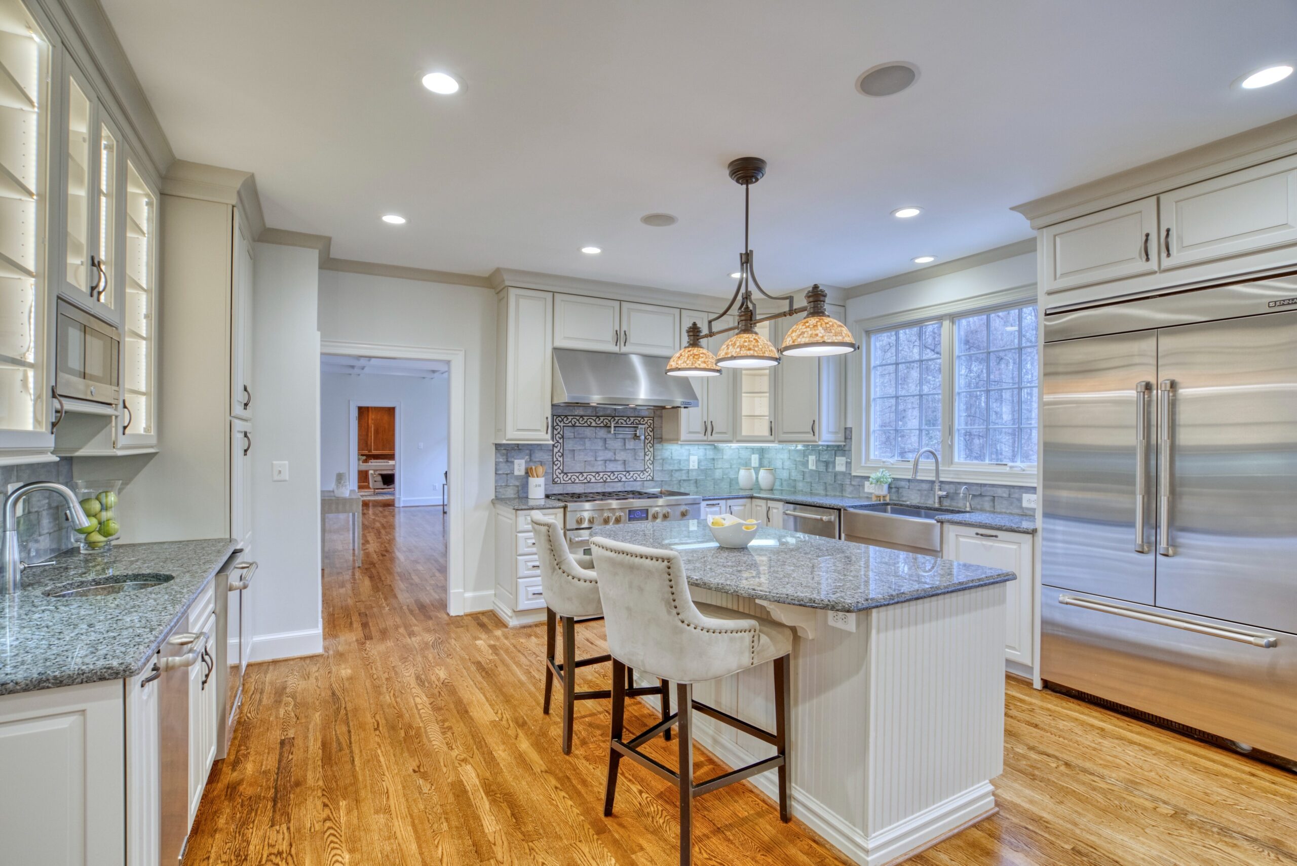 Professional interior photo of 718 Potomac Knolls Dr - showing the kitchen with stainless appliances, white cabinets, granite counters and 2 sinks