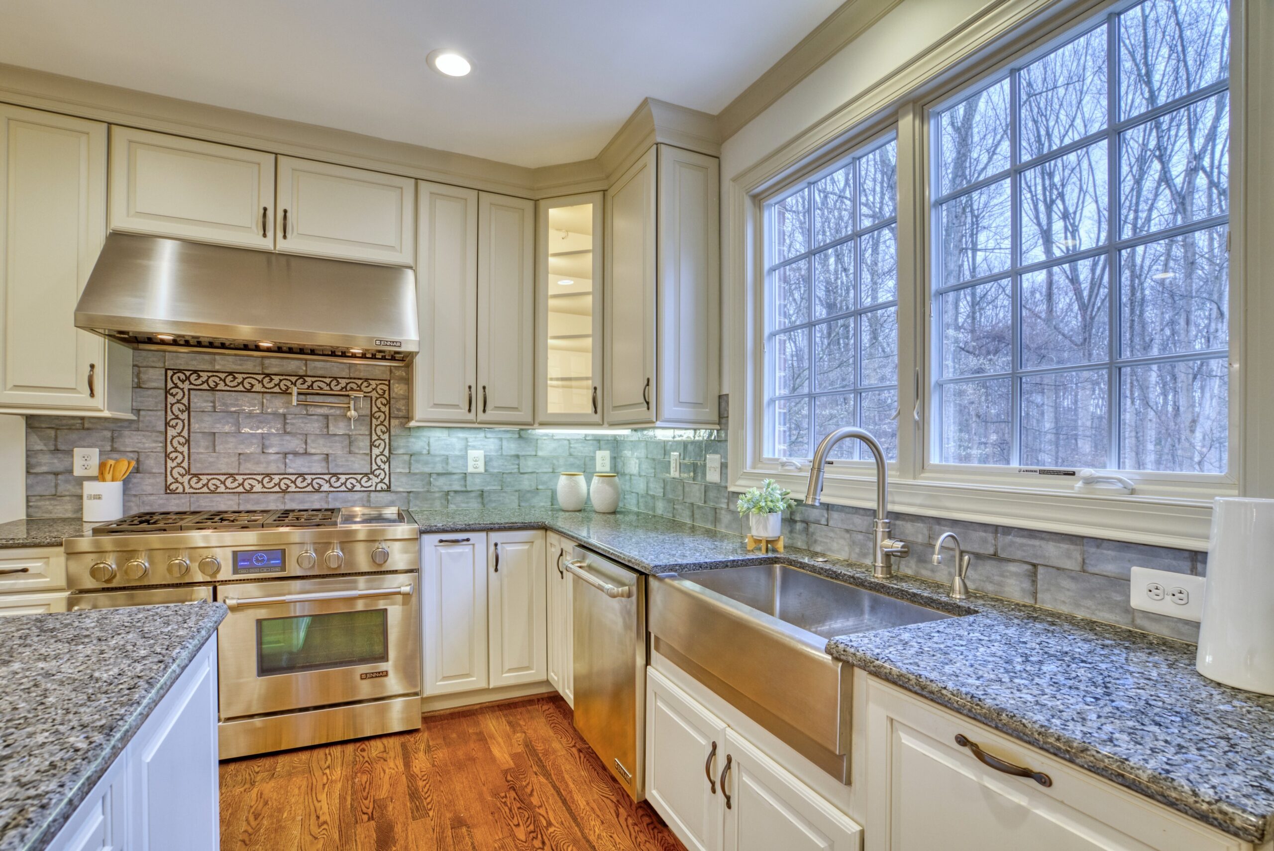 Professional interior photo of 718 Potomac Knolls Dr - showing the kitchen with stainless appliances, white cabinets, granite counters and 2 sinks