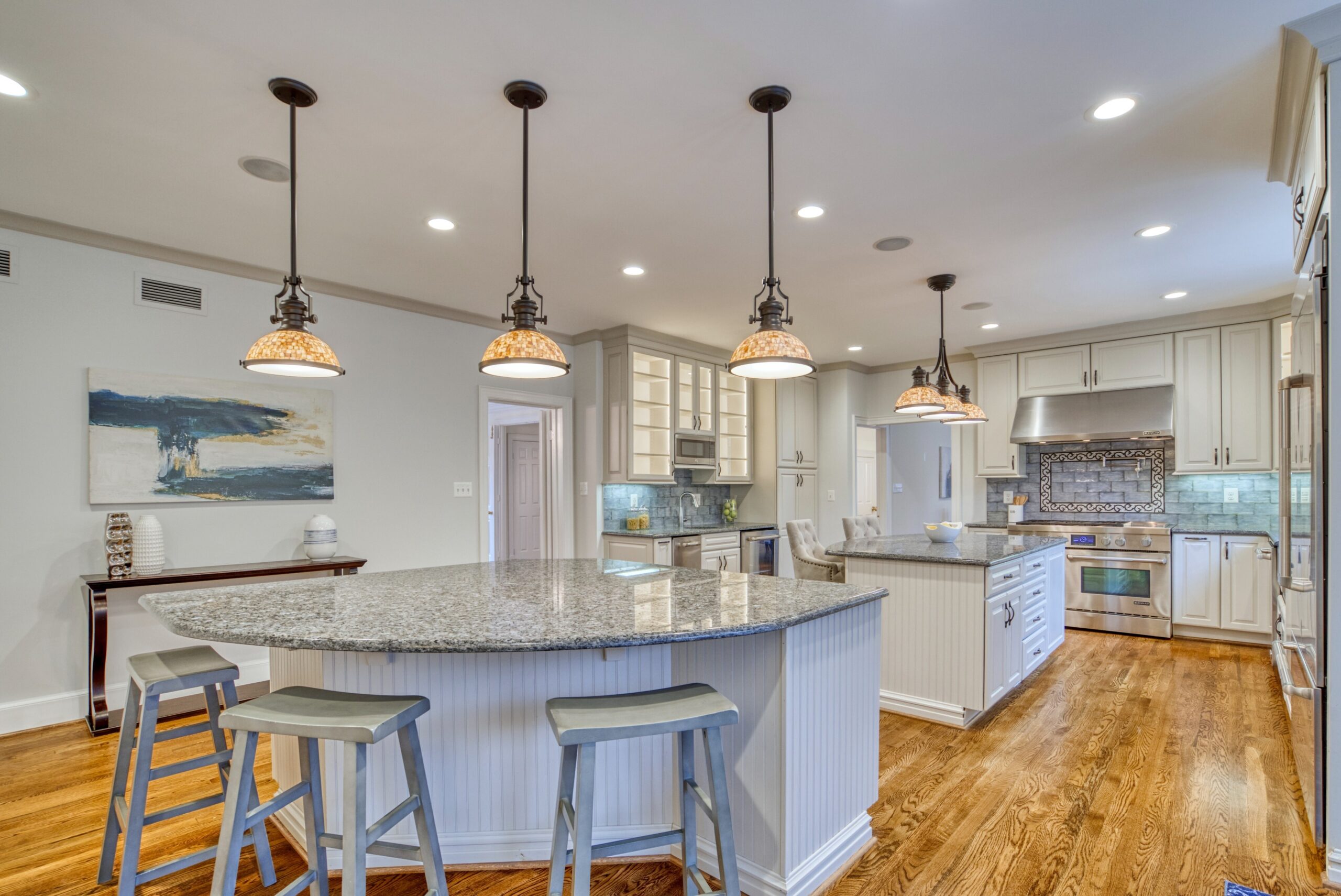 Professional interior photo of 718 Potomac Knolls Dr - showing the kitchen with TWO granite islands, luxury range and designer lighting