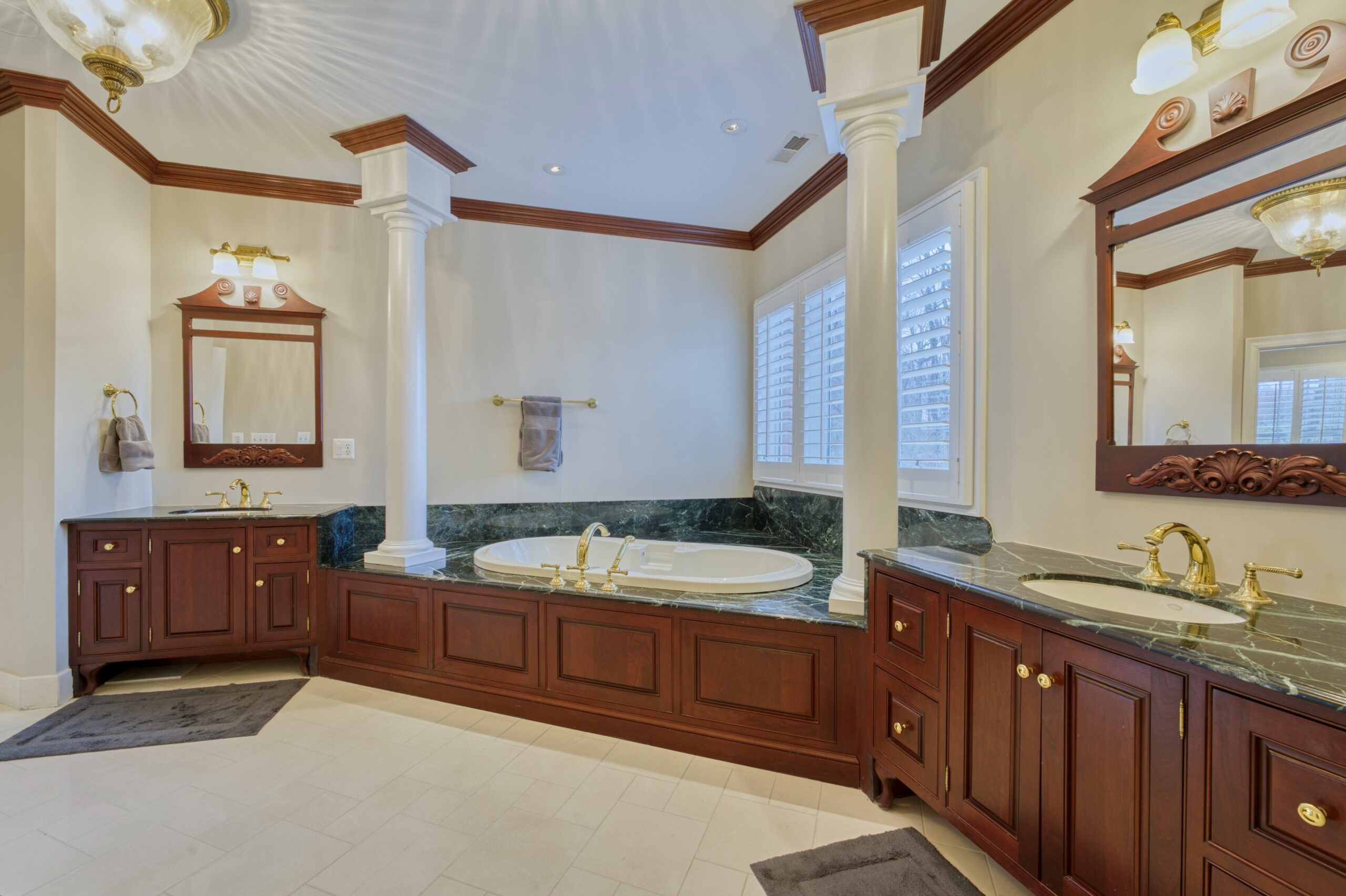 Interior professional photo of 40573 Spectacular Bid Place - showing one of the primary bathrooms with deep soaking tub flanked by 2 columns and separate vanities