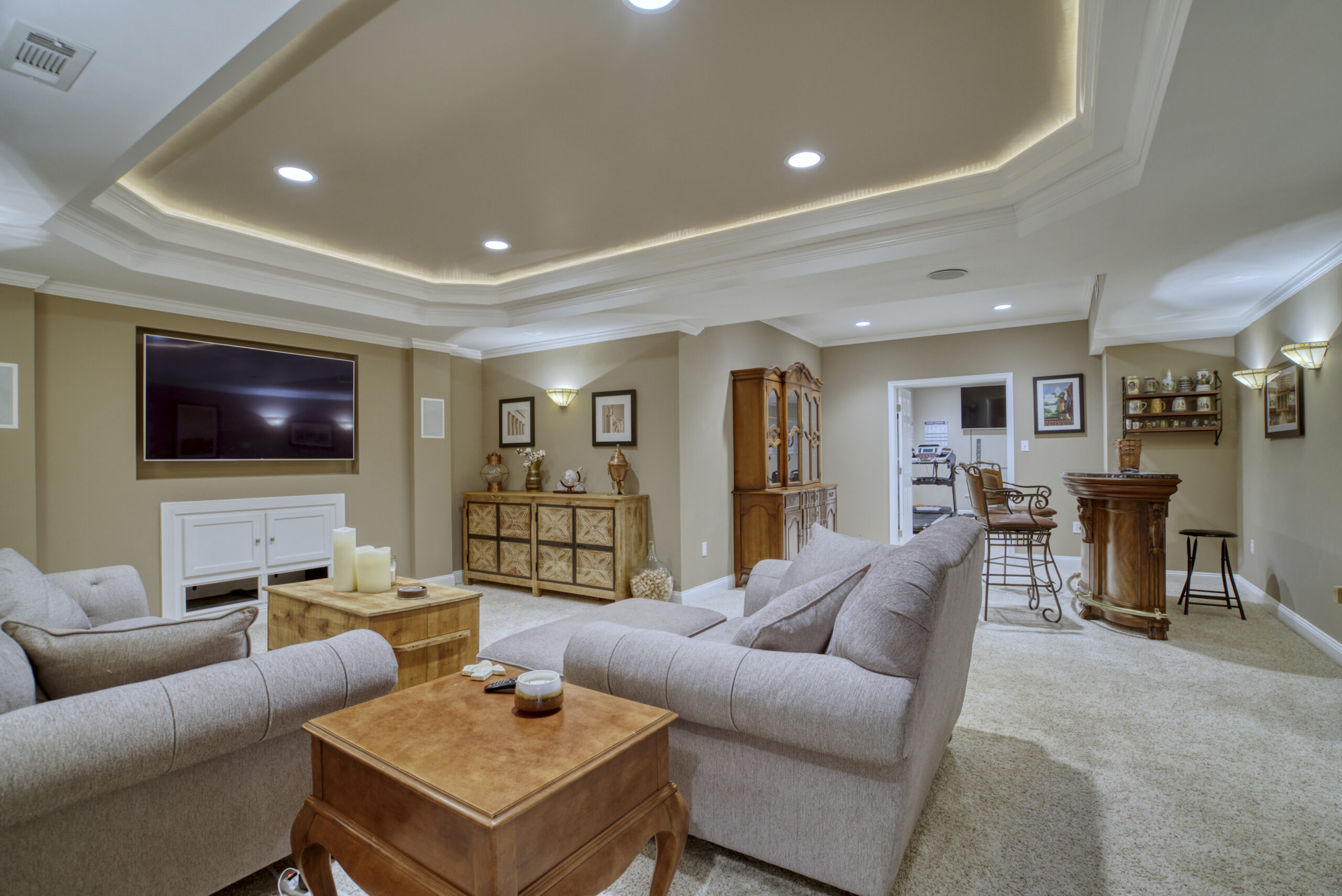 Professional interior photo of 9701 Chilcott Manor Way - showing the basement media area with trey ceiling and bar in the background