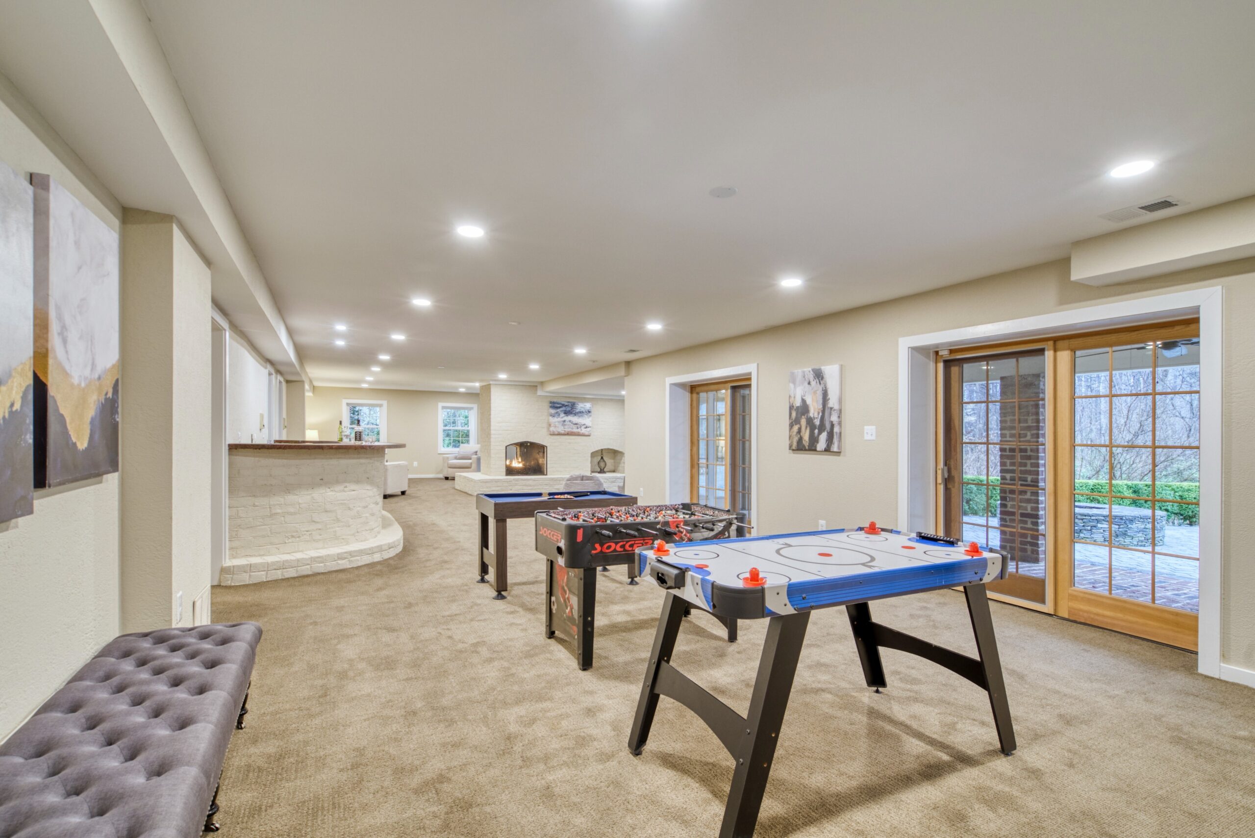 Professional interior photo of 718 Potomac Knolls Dr - showing the finished lower level with several areas to entertain looking out the doors to the backyard