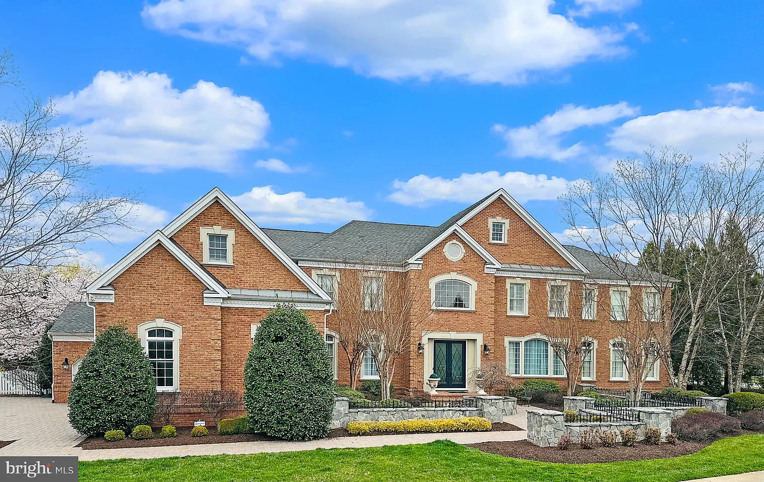 Professional exterior photo shot by SOMEONE ELSE in 2022 showing dull, flat, artificial colors of the front of a stately brick home