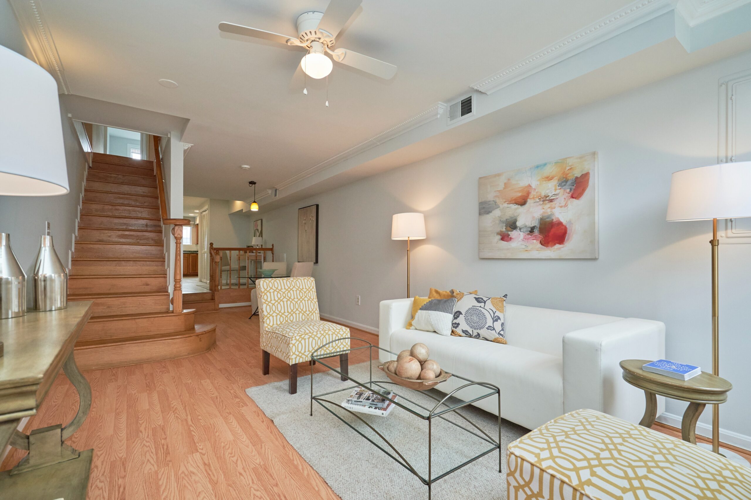 Professional interior photo of 1313 K Street SE, Washington, DC - showing the living room inside the front door and the staircase leading to the second floor