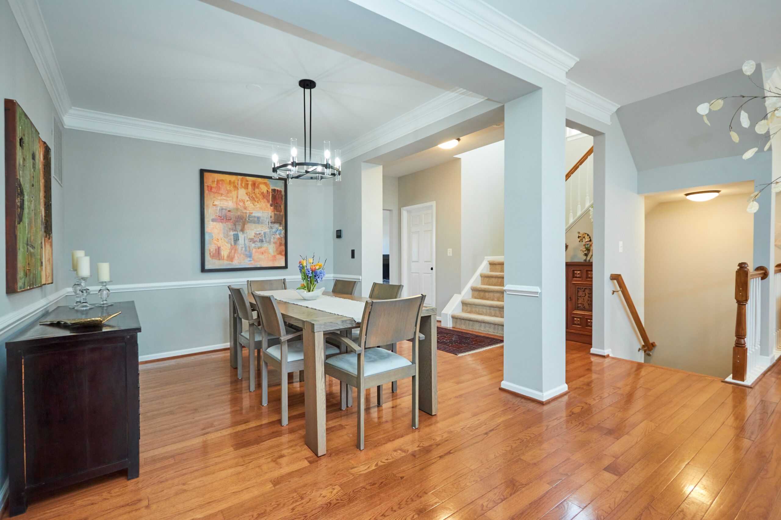 Professional interior photo of 25499 Beresford Drive, Chantilly, Virginia - showing the dining room on the main level with hardwood floors and staircase leading to the top and to the bottom floors