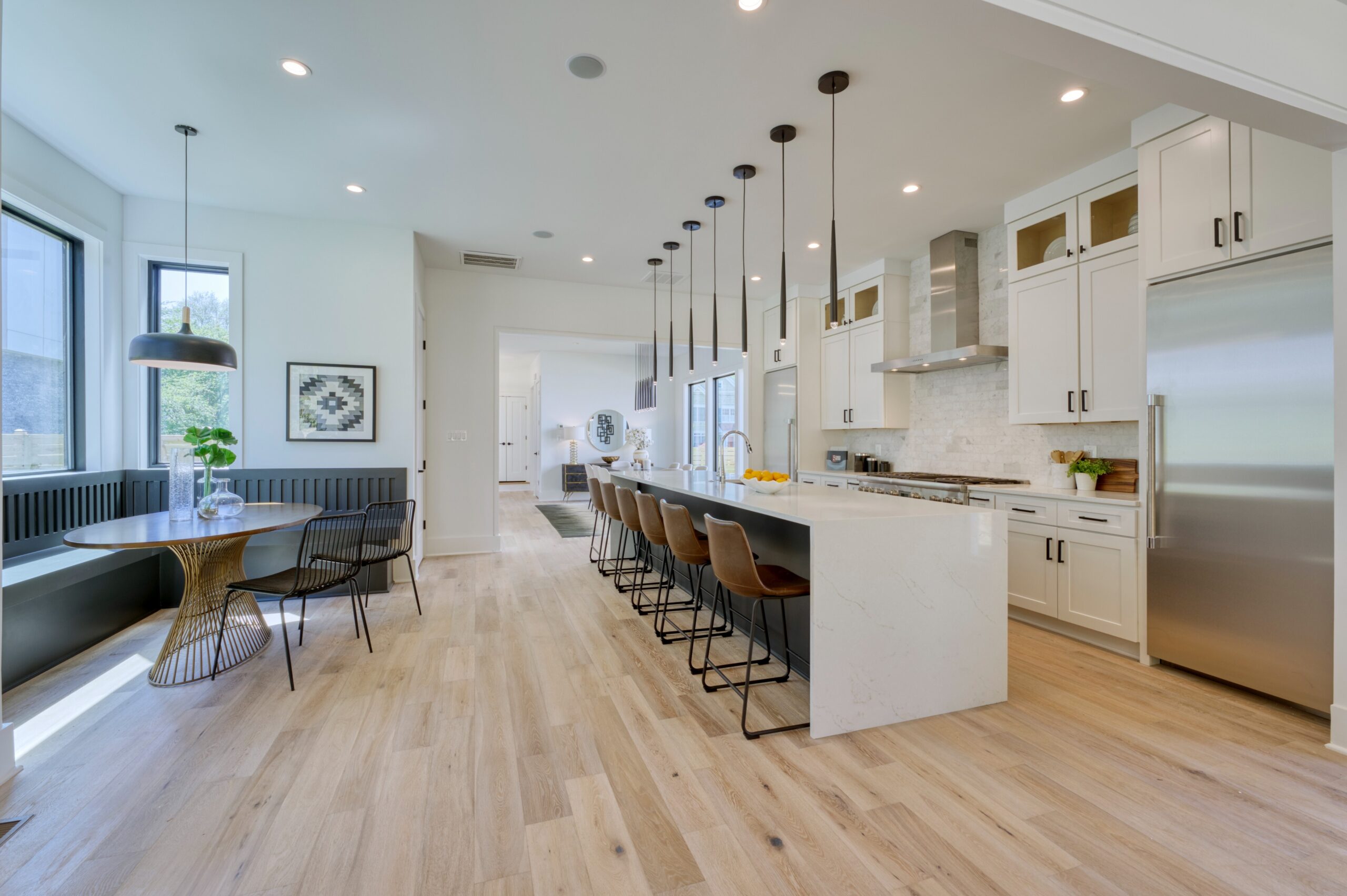 Professional interior photo of 1137 Buchanan St in McLean, VA - showing the kitchen and breakfast area, with built in benches for the breakfast nook, large waterfall island and white quartz custom kitchen