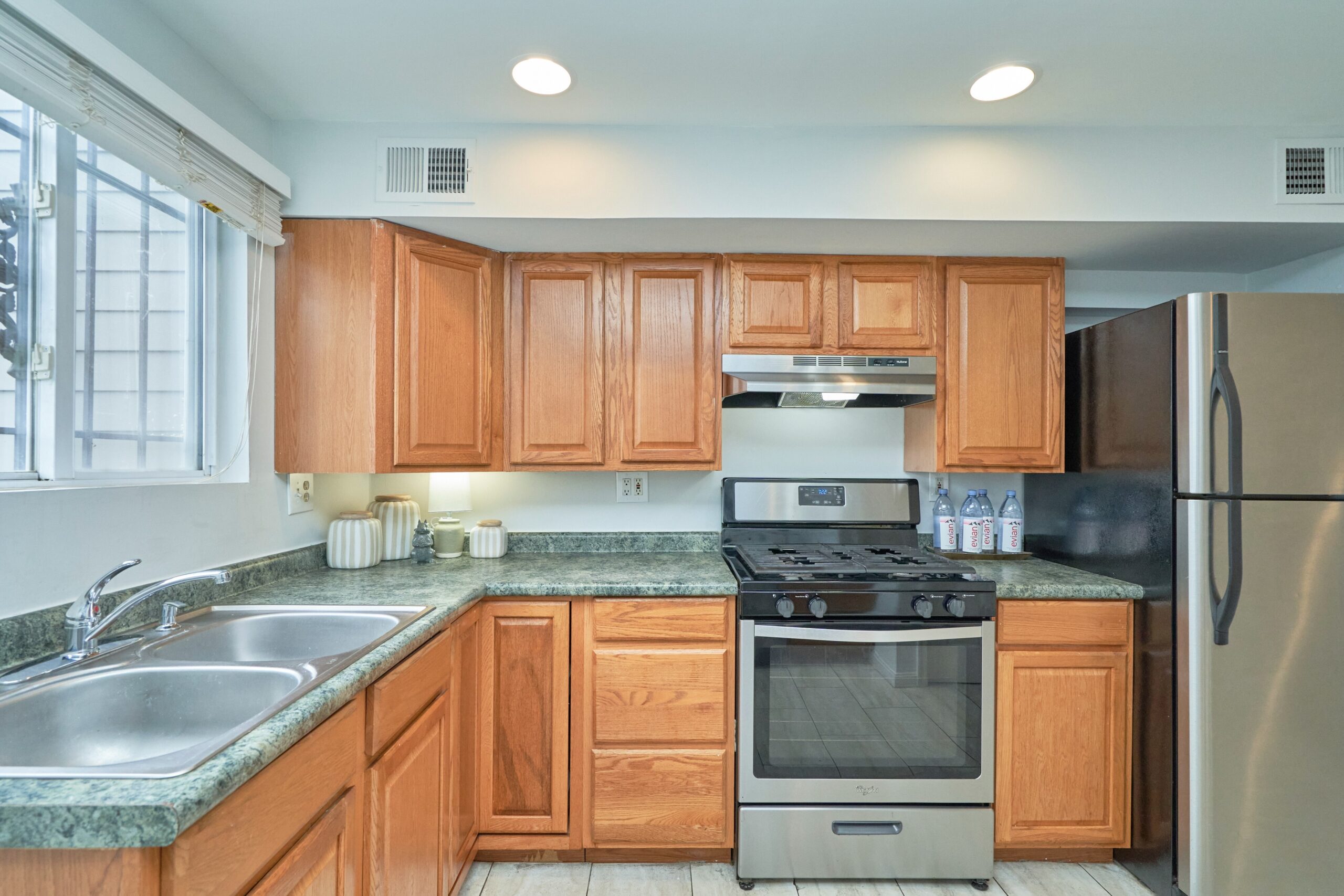 Professional interior photo of 1313 K Street SE, Washington, DC - showing the kitchen with walnut cabinets and stainless appliances 