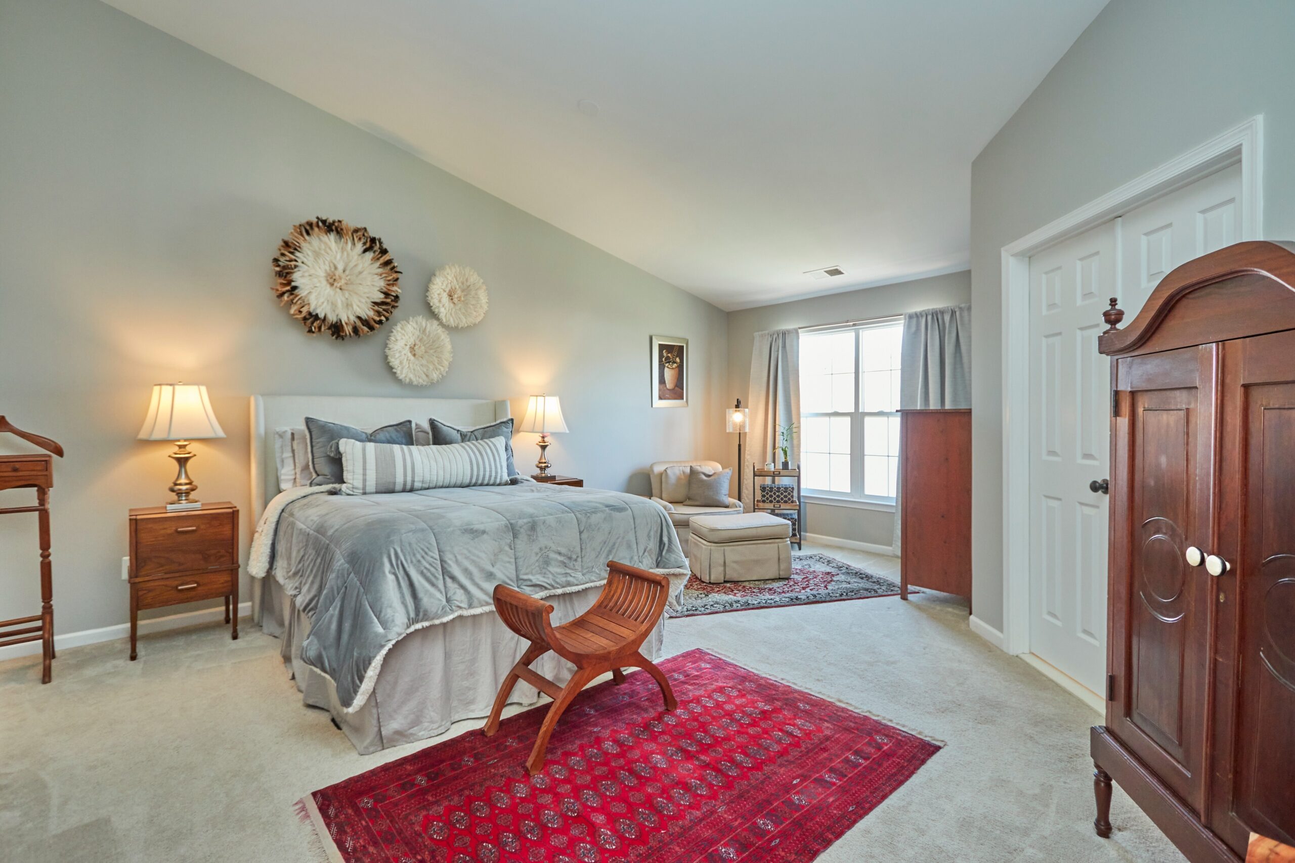 Professional interior photo of 25499 Beresford Drive, Chantilly, Virginia - showing the primary bedroom with vaulted ceiling, sitting area, and french doors to the bathroom