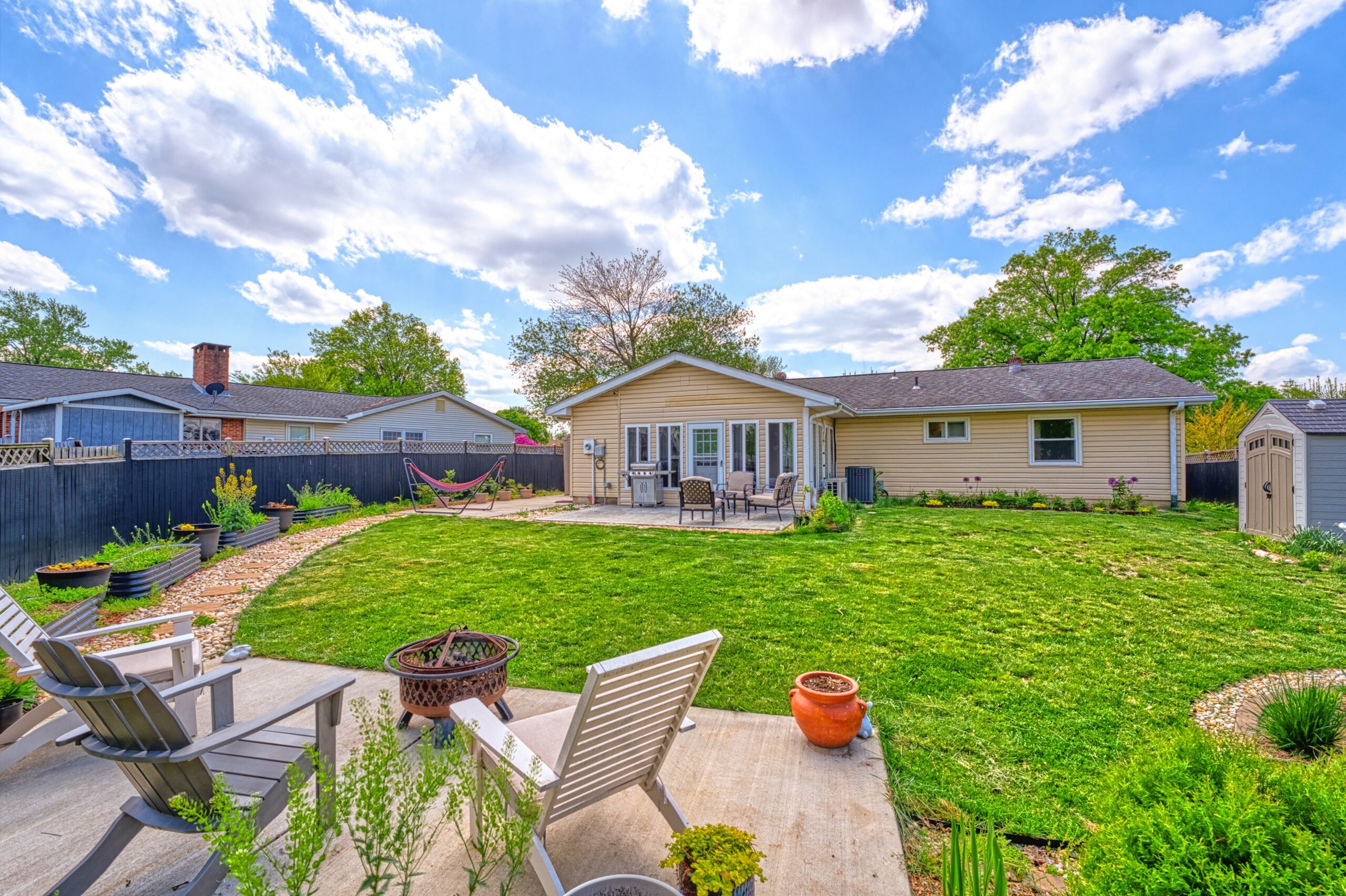 professional exterior photo of 102 S Harrison Road, Sterling, VA - showing the backyard view from the detached patio, looking back towards the home.