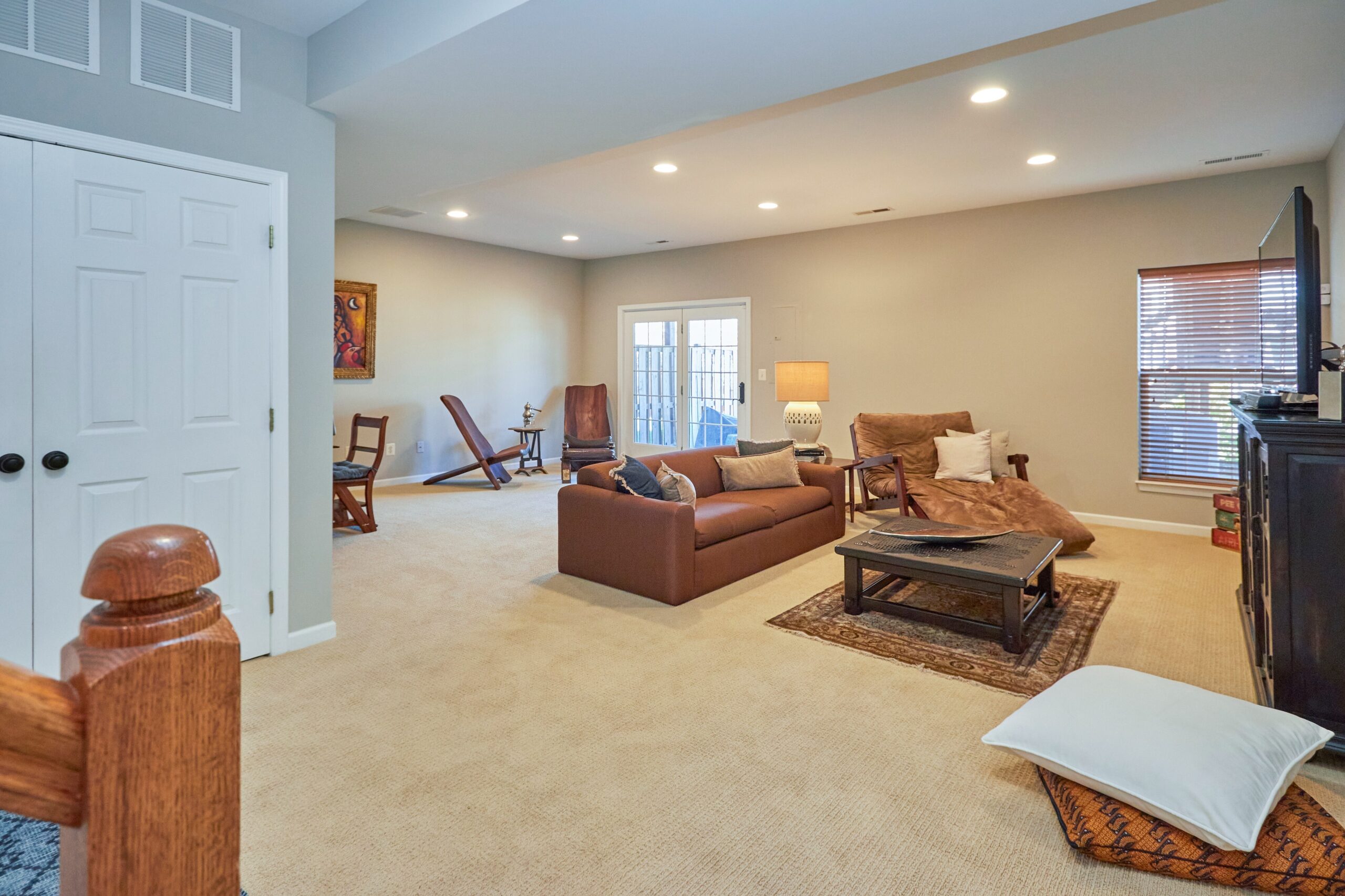 Professional interior photo of 25499 Beresford Drive, Chantilly, Virginia - showing the ground floor living area, a big carpeted, open room  with multiple entertaining spaces