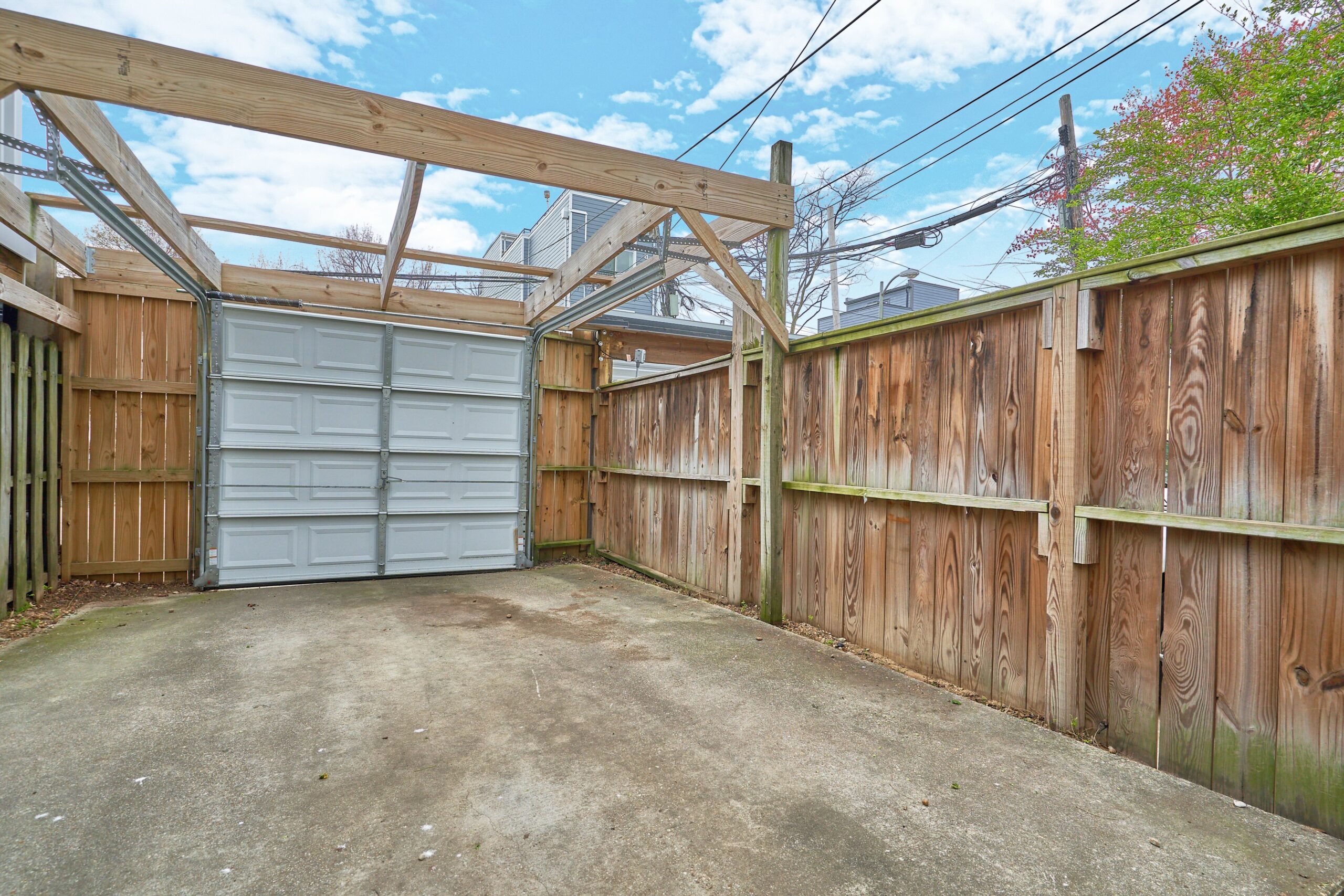 Professional exterior photo of 1313 K Street SE, Washington, DC - showing the secured rear carport area with garage door