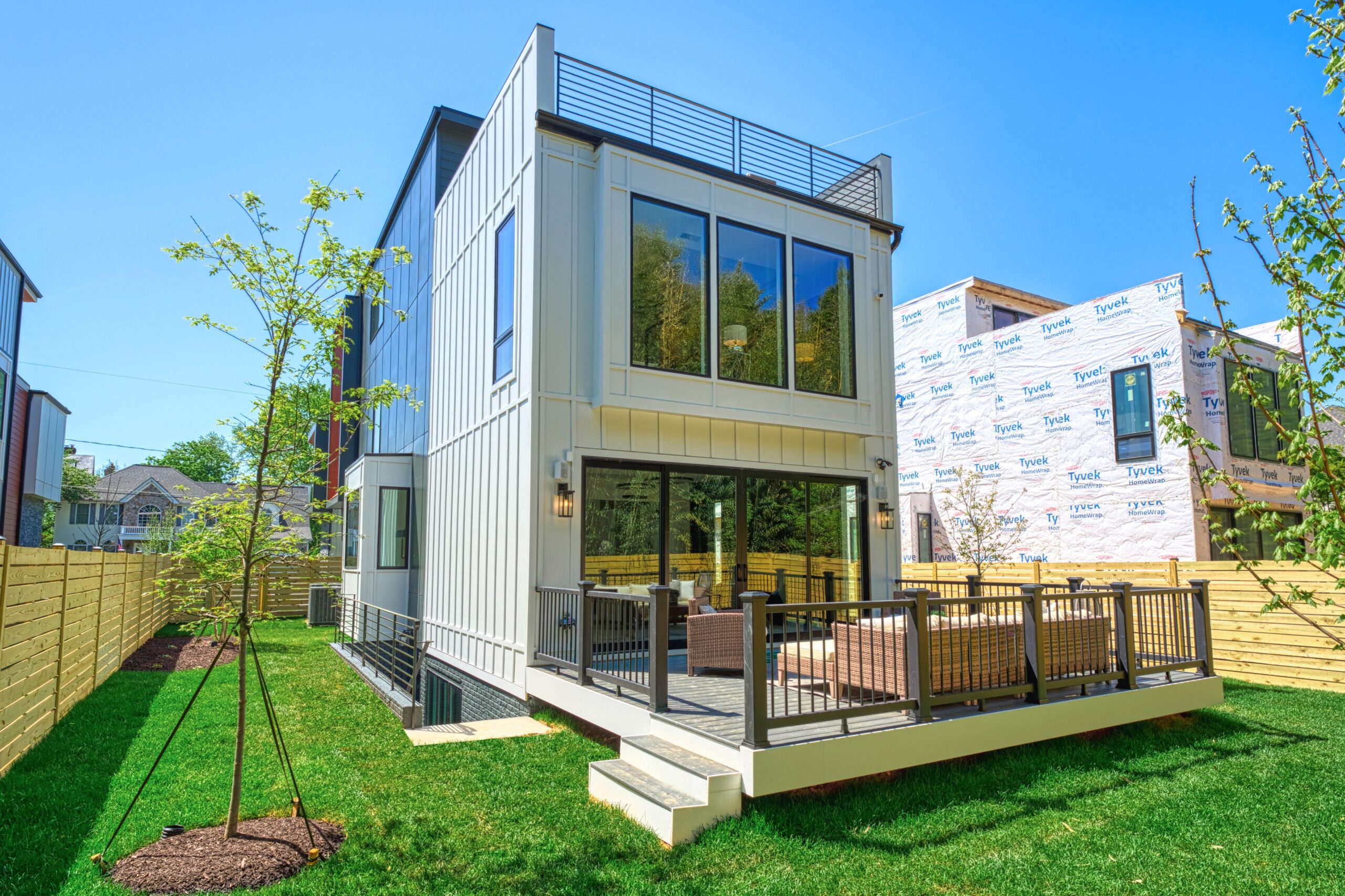Professional exterior photo of 1137 Buchanan St in McLean, VA - showing the rear view of a brand new construction modern home with a ground level floating deck and rooftop deck