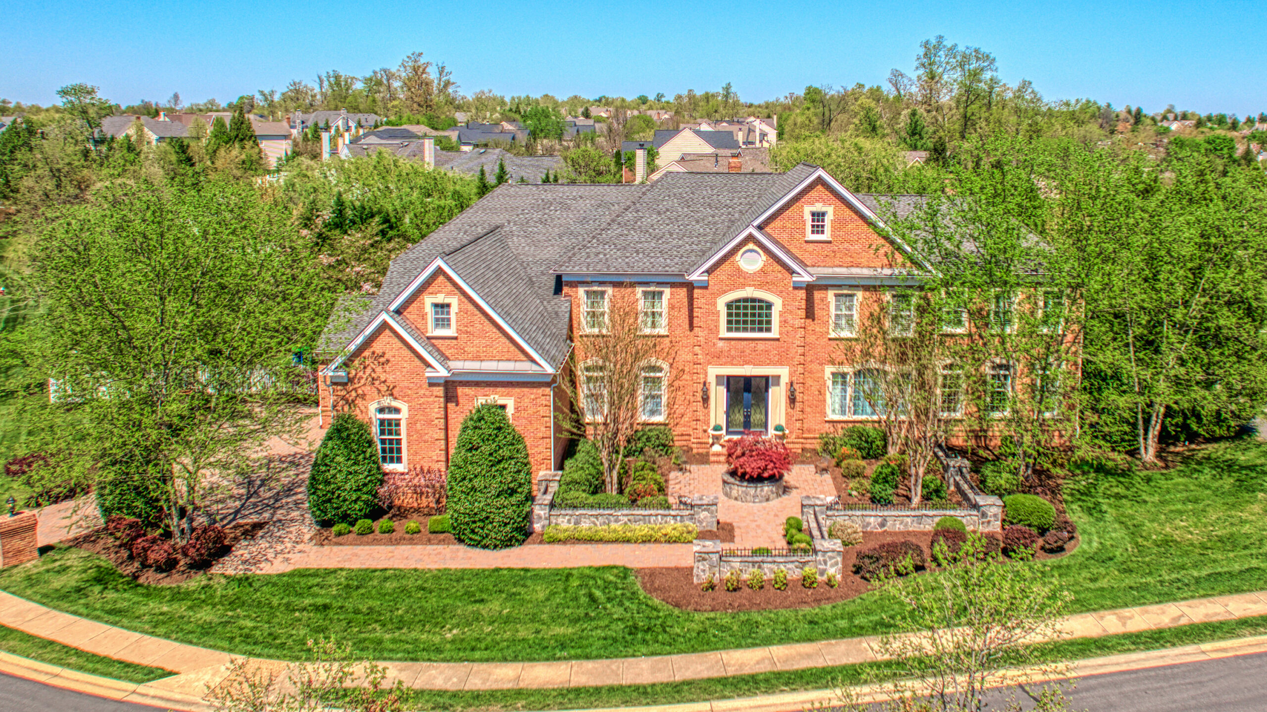 Professional exterior photo shot by Sky Blue Media using Fusion Photography in 2023 showing true, crisp, vibrant colors in an aerial photo of the front of a stately brick home