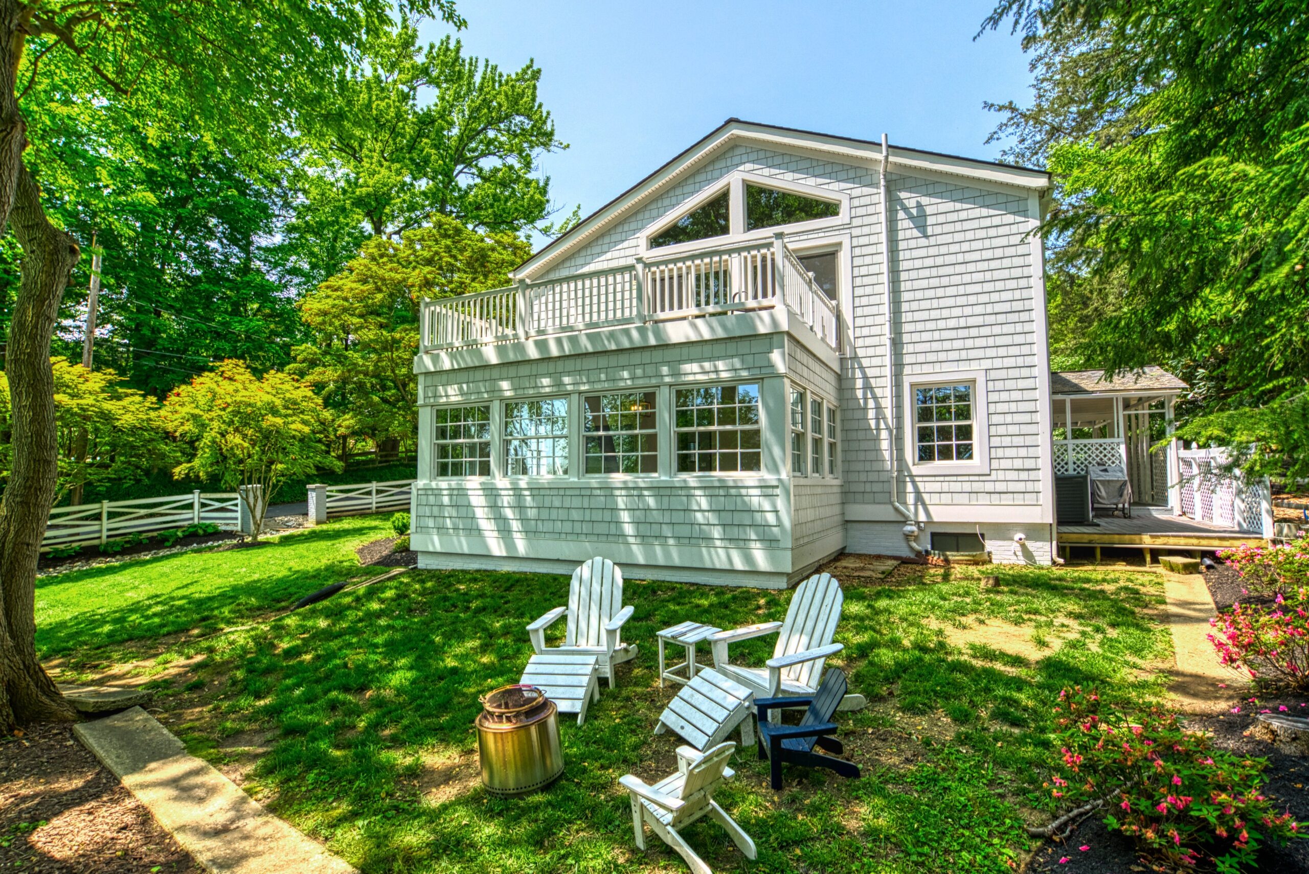Professional exterior photo of 209 Norwood Road, Annapolis, MD - showing the yard outside of the sunroom with 3 lawn chairs
